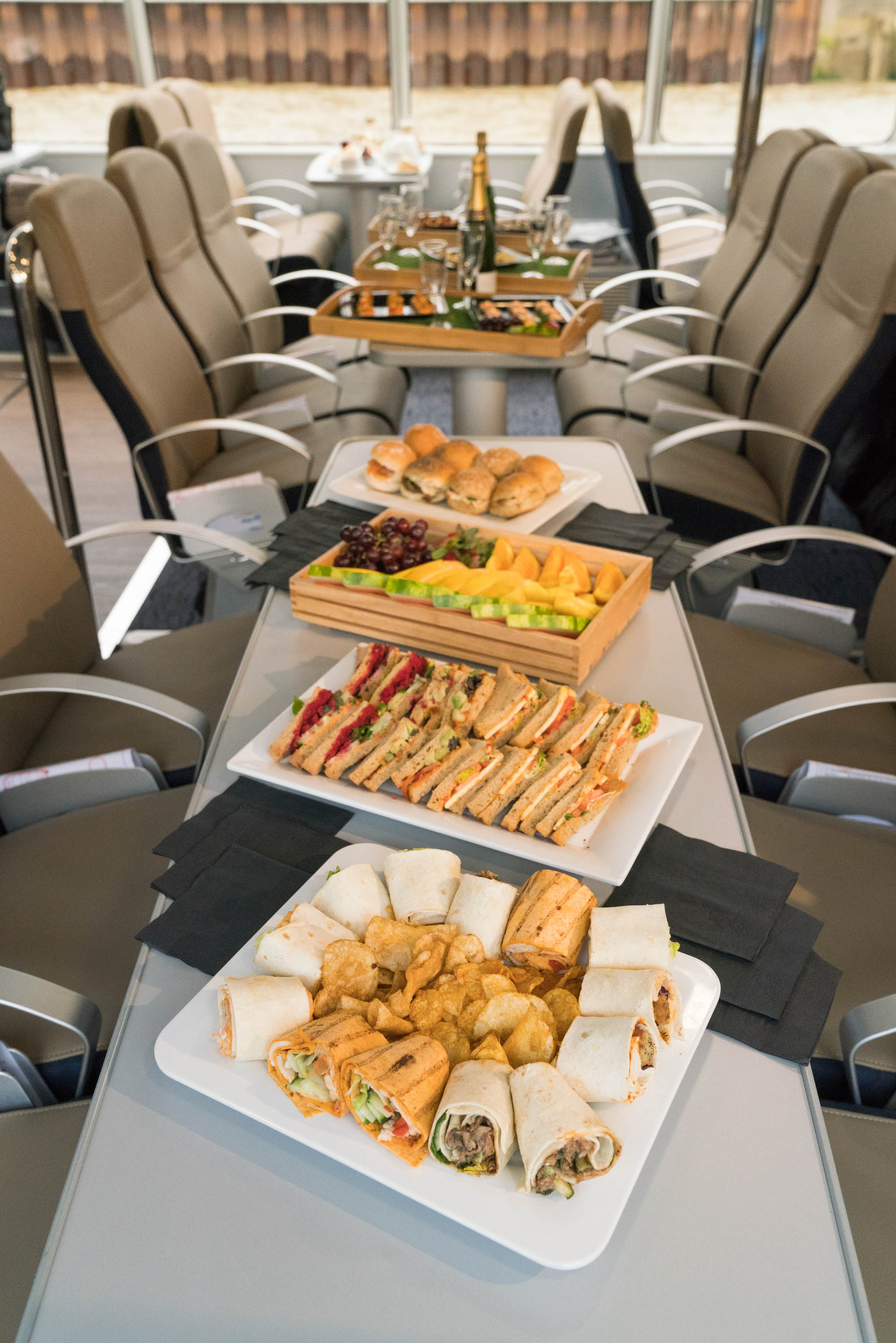 Corporate meeting refreshments: elegant sandwiches, fruit, and pastries on stylish platters.