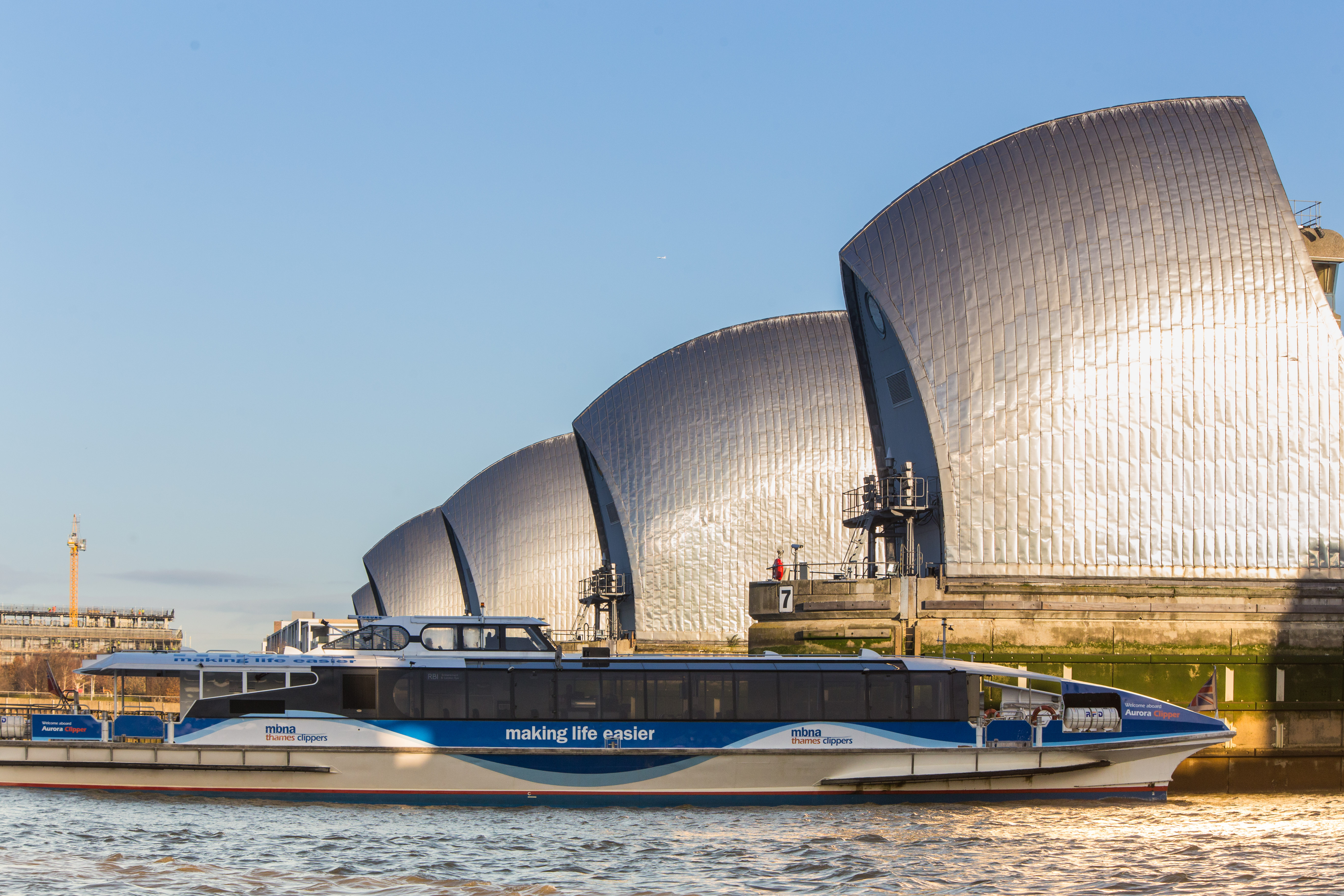 Sleek event boat Venus Clipper near flood barriers for corporate gatherings and private events.