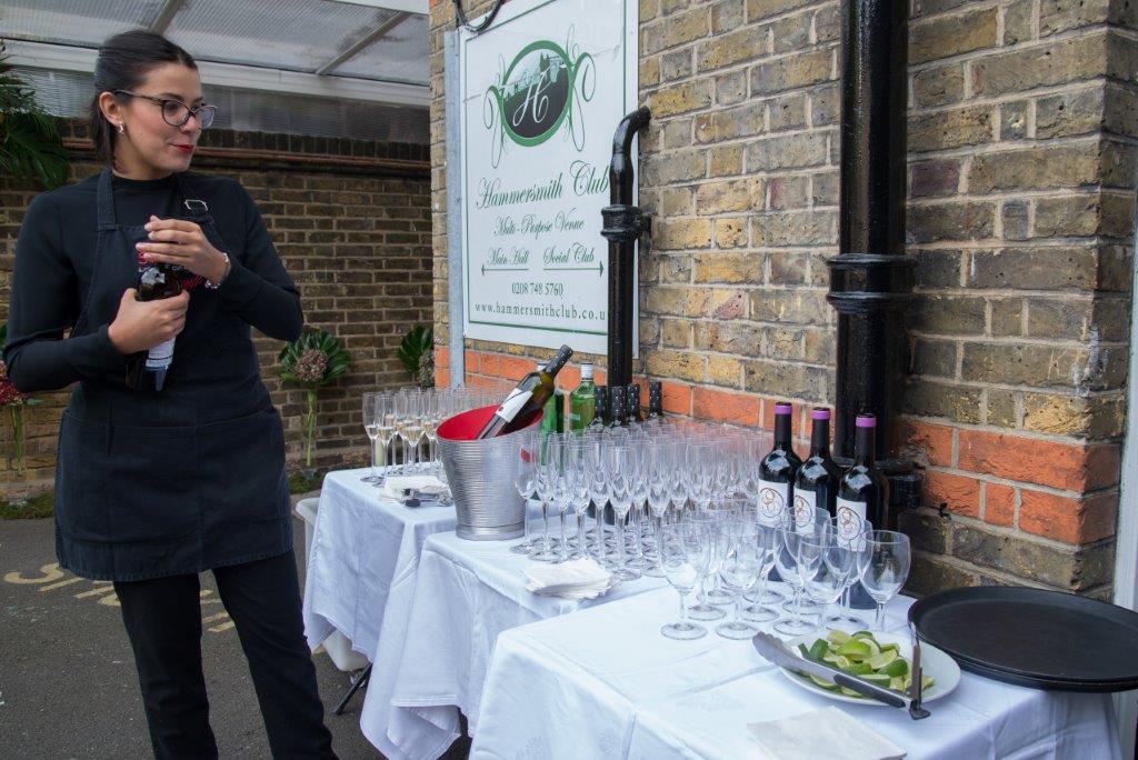 Outdoor event setup at Hammersmith Club with elegant table and professional staff.