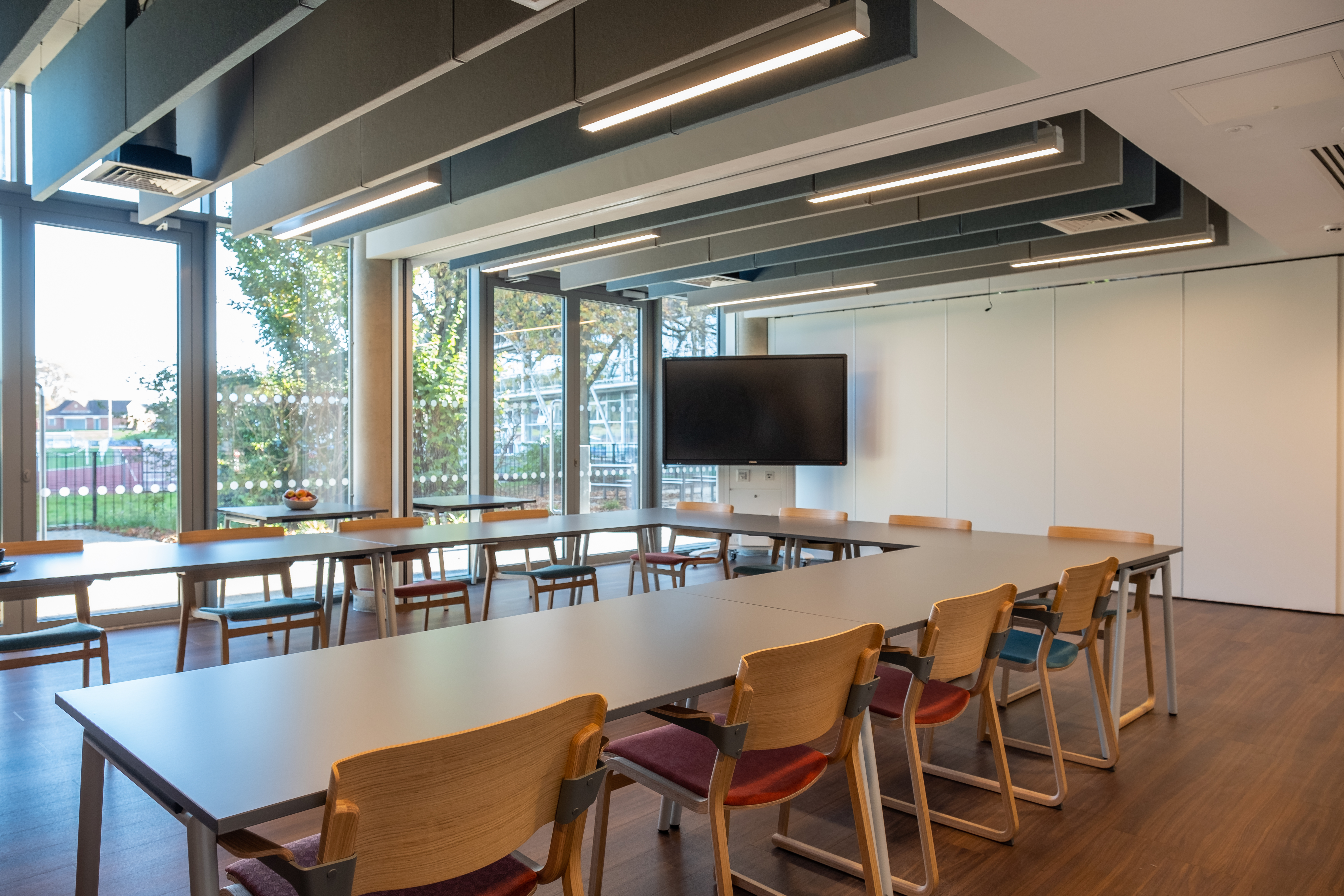 Modern seminar room with long table and natural light for presentations and meetings.