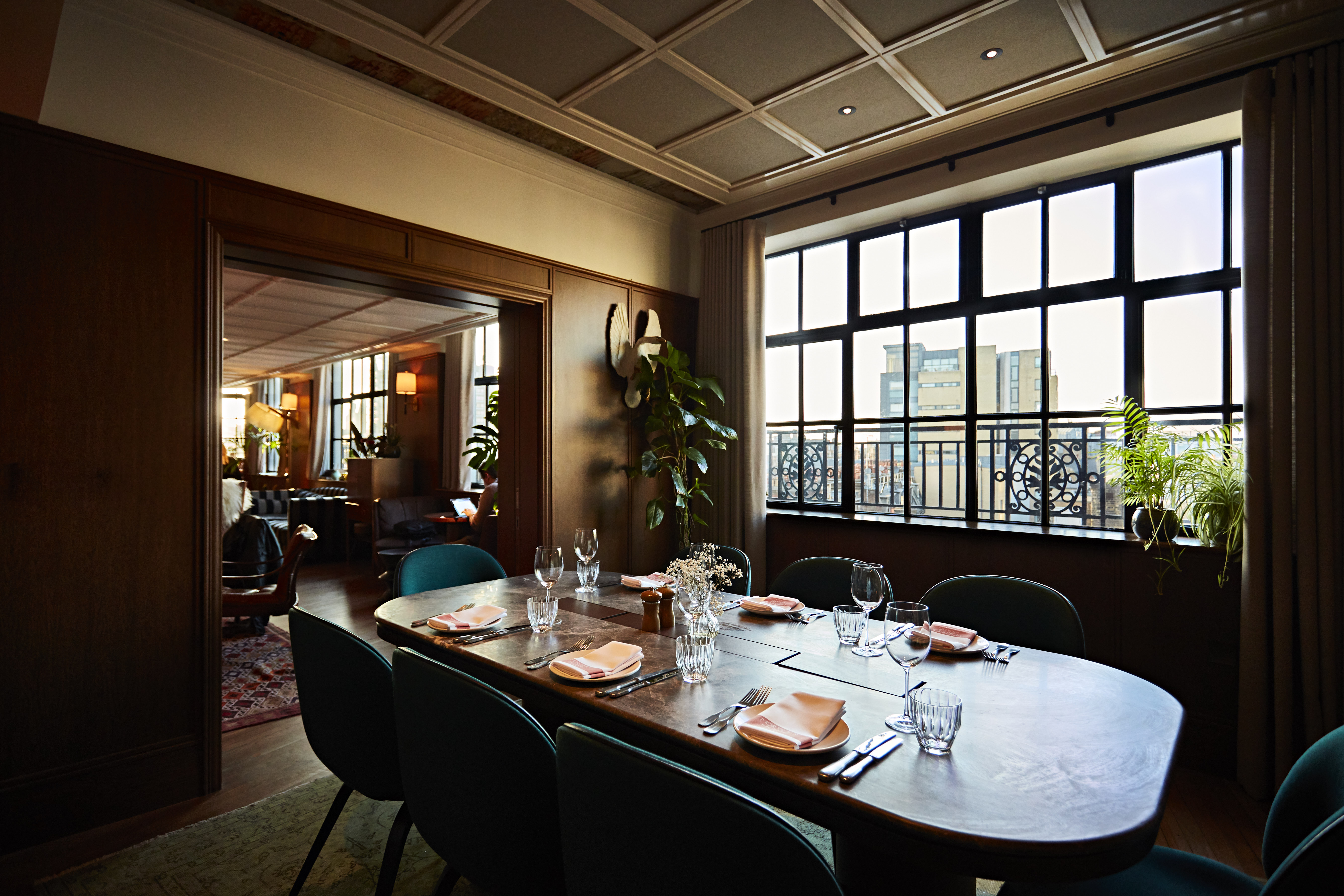 Private dining room with large wooden table, ideal for intimate meetings and events.
