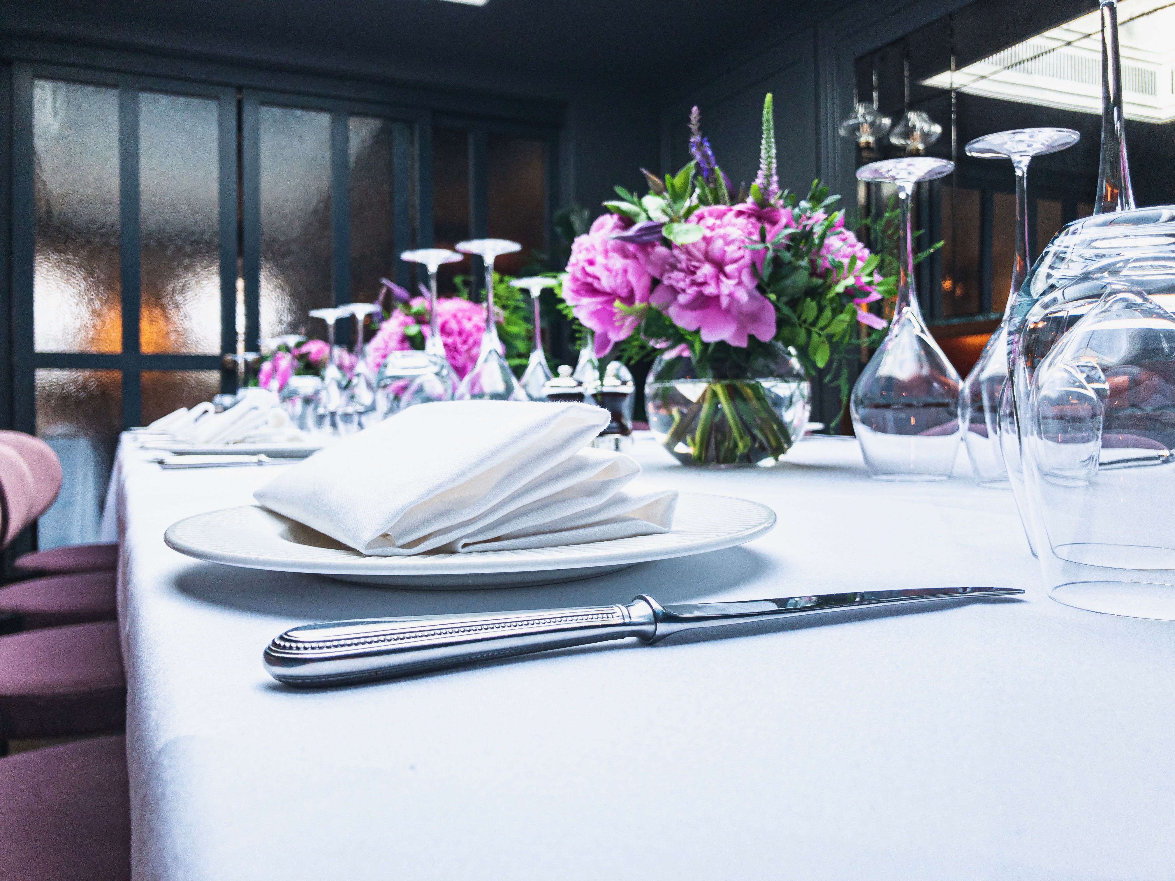 Elegant dining table setup with floral centerpieces for formal dinner or corporate event.