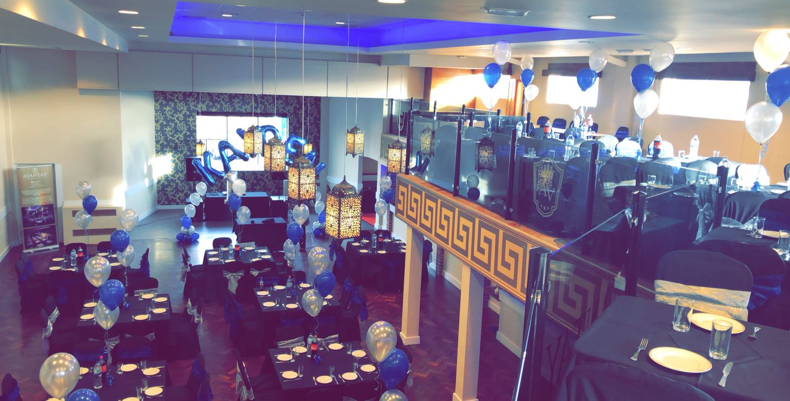 Elegant corporate event space with decorative table settings and balloons.