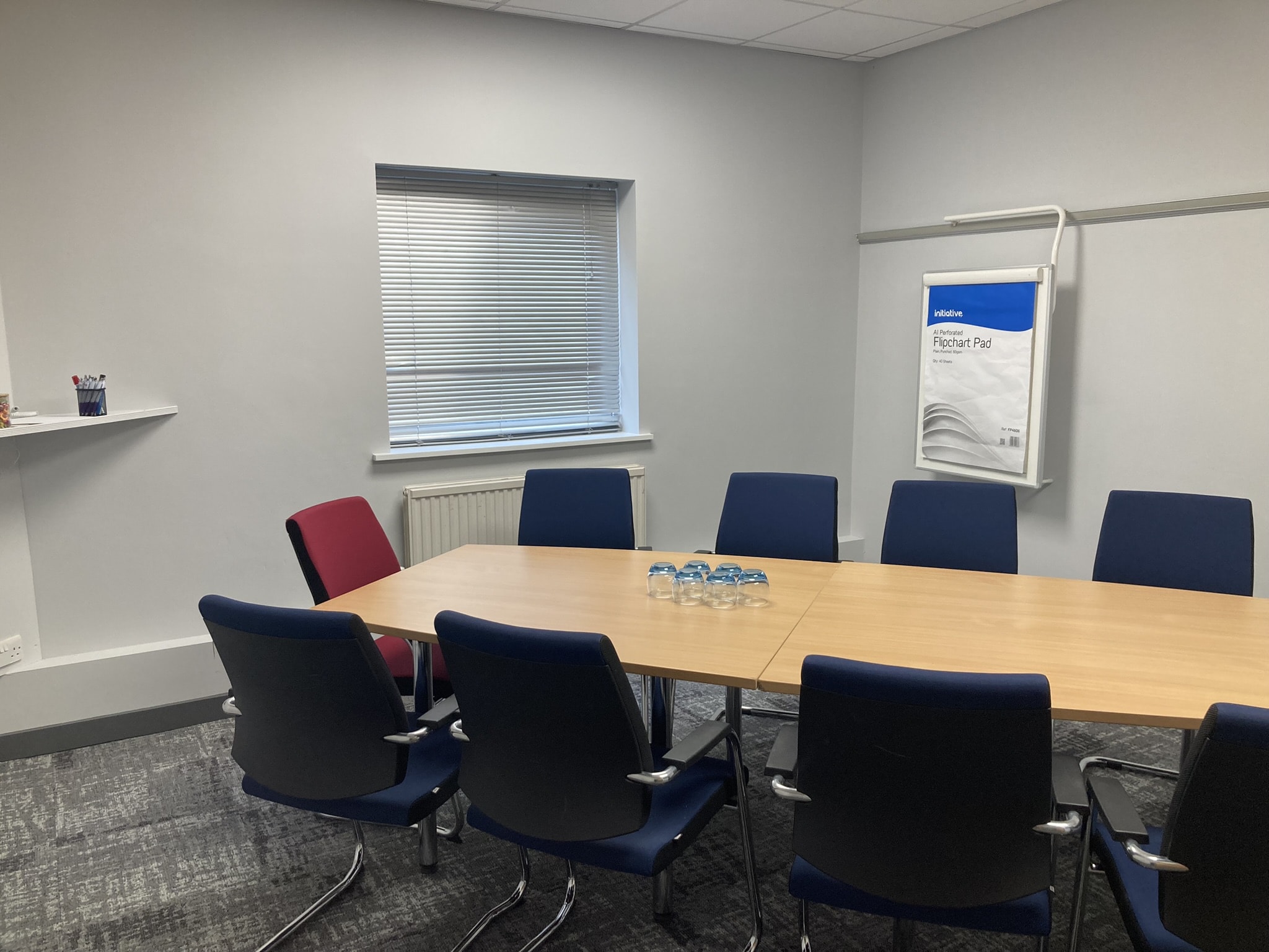 Large meeting room with rectangular table and blue chairs at Burleigh Court Conference Centre.