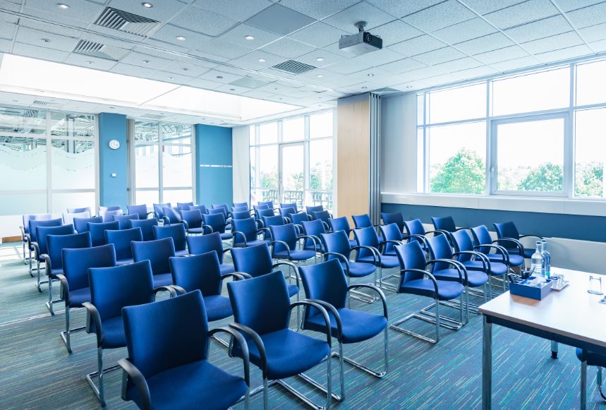 Brunel meeting room with blue chairs, natural light for conferences and events.