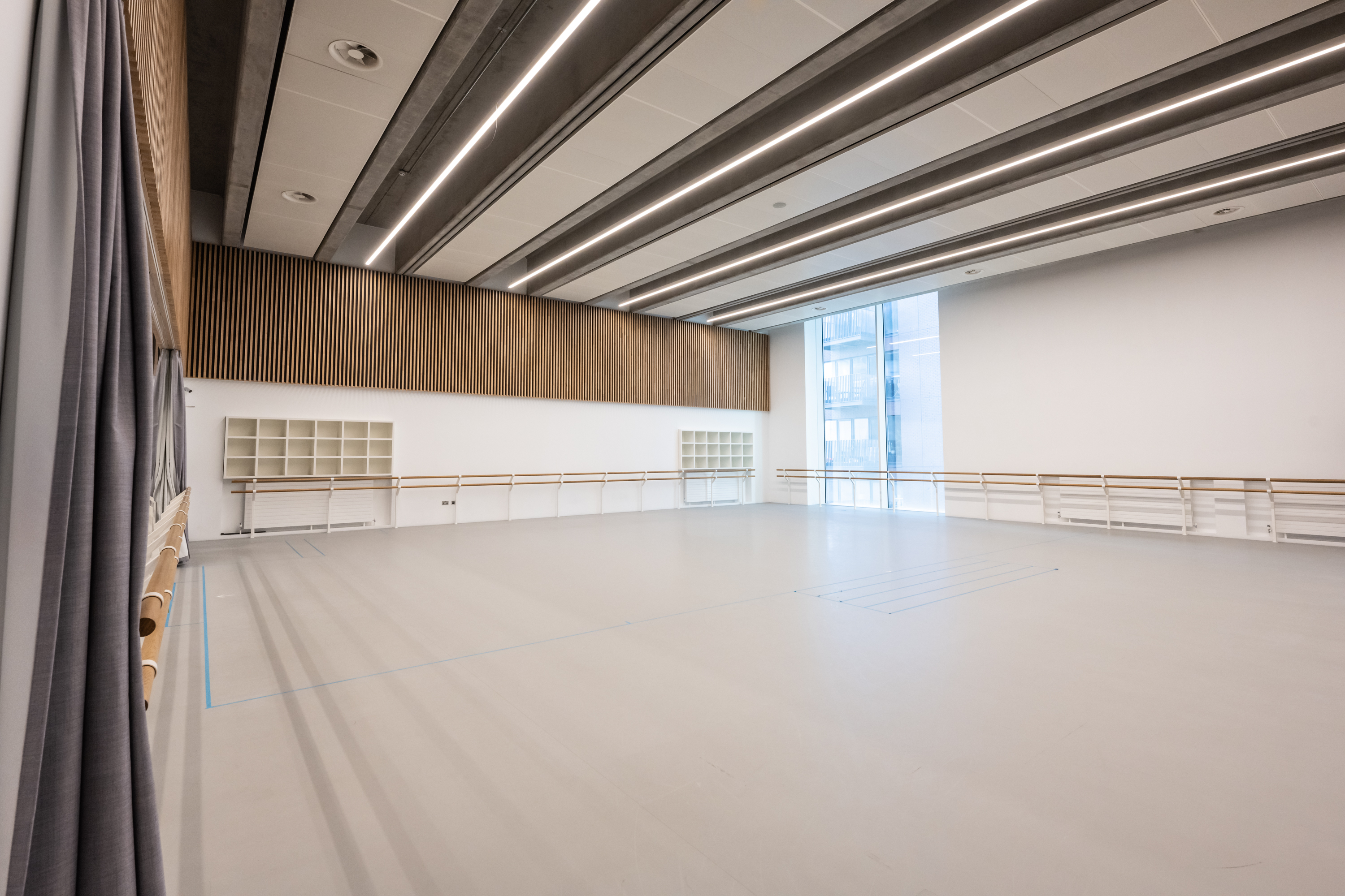 Spacious rehearsal studio with large windows, ideal for workshops and corporate events.