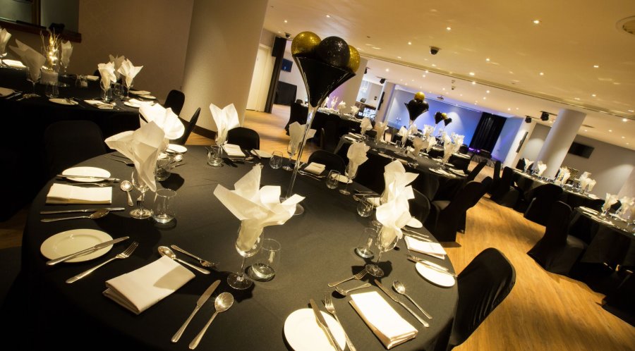 Elegant event space at Alea Casino, set for formal dinner with black tablecloths and balloons.