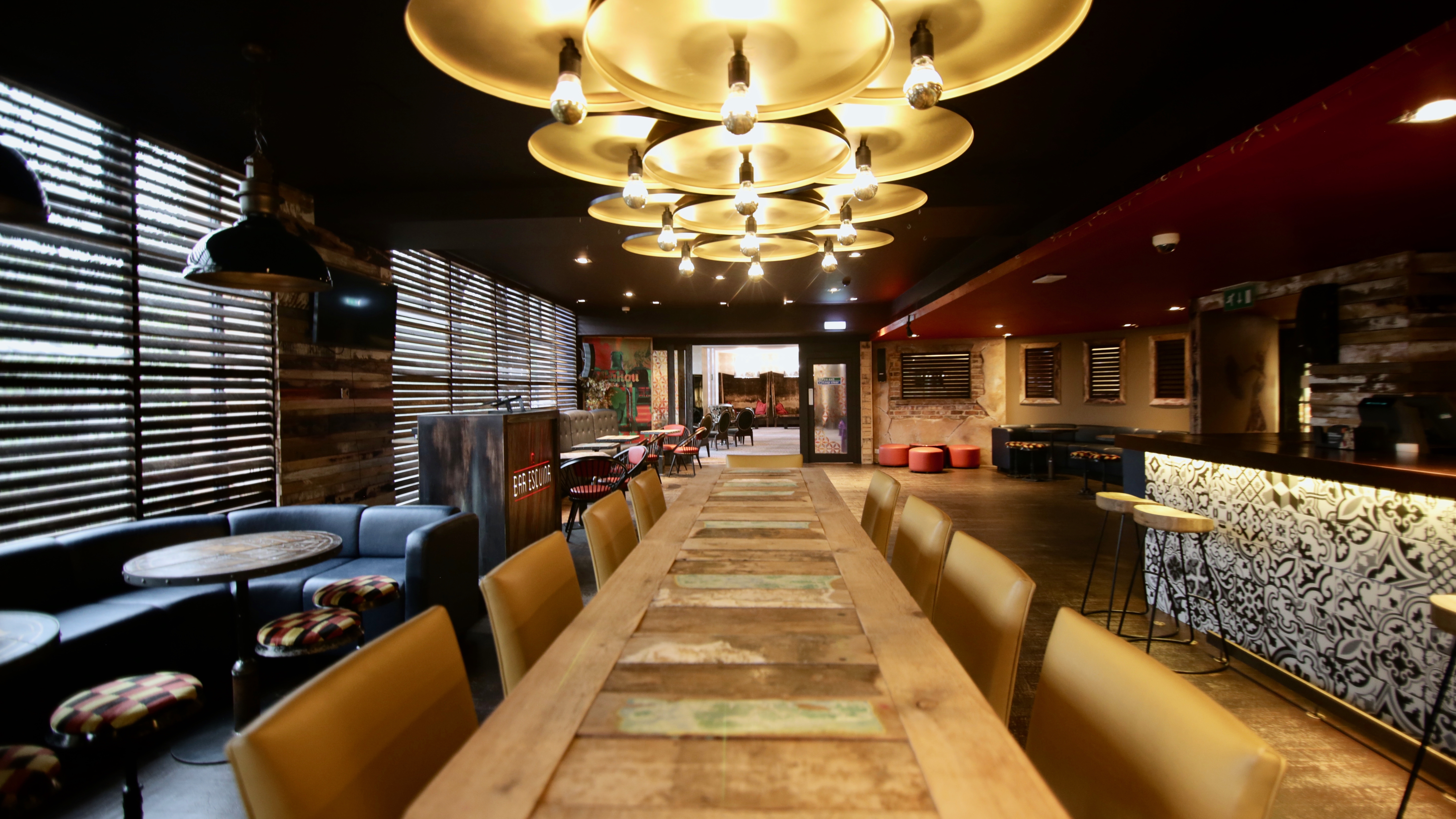 Stylish Bar Esquina event space with wooden table, ideal for meetings and gatherings.