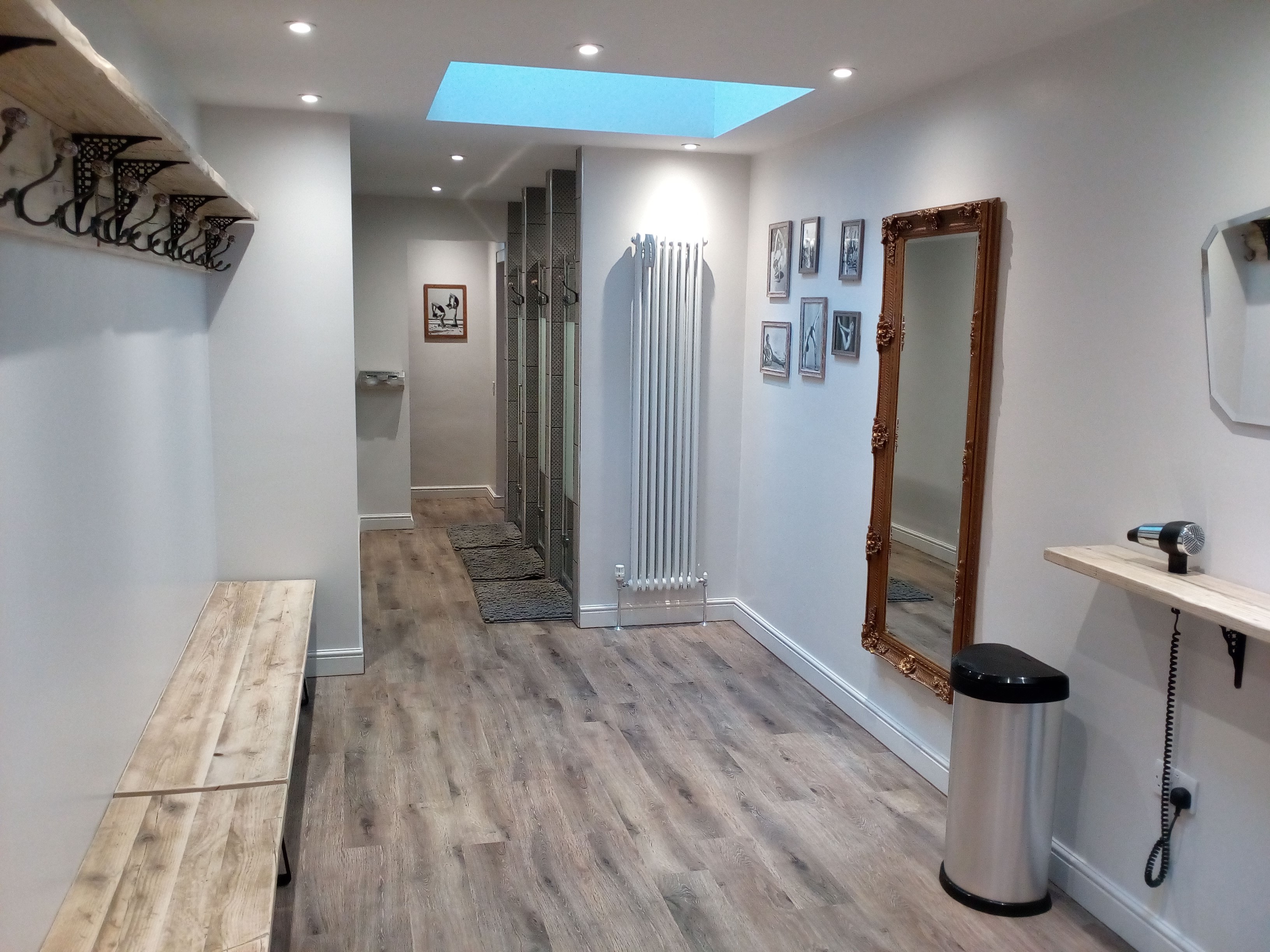 Modern Yoga & Pilates studio hallway with wooden benches, ideal for events and mingling.
