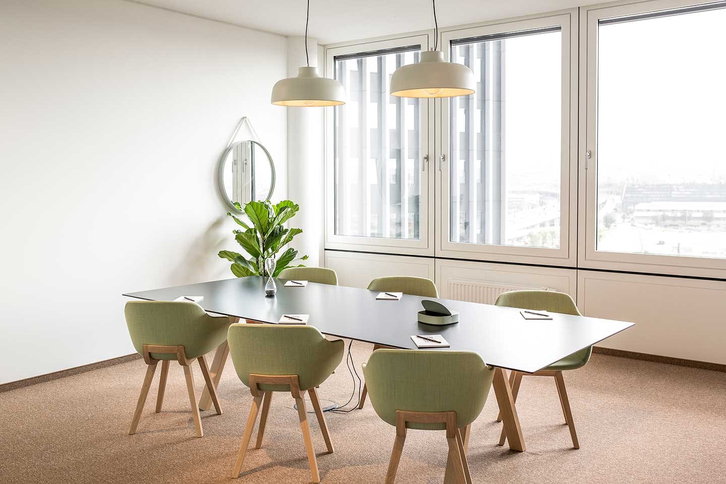 Modern meeting room with sleek table and natural light, perfect for collaboration sessions.