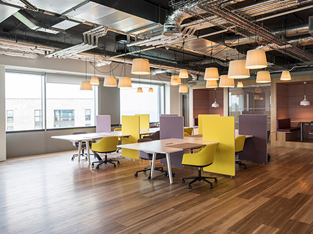 Modern open office space with colorful dividers for creative meetings and workshops.
