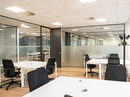 Modern open office space with glass partitions for workshops and team meetings.