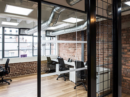 Modern office space with exposed brick walls, ideal for meetings and collaboration.