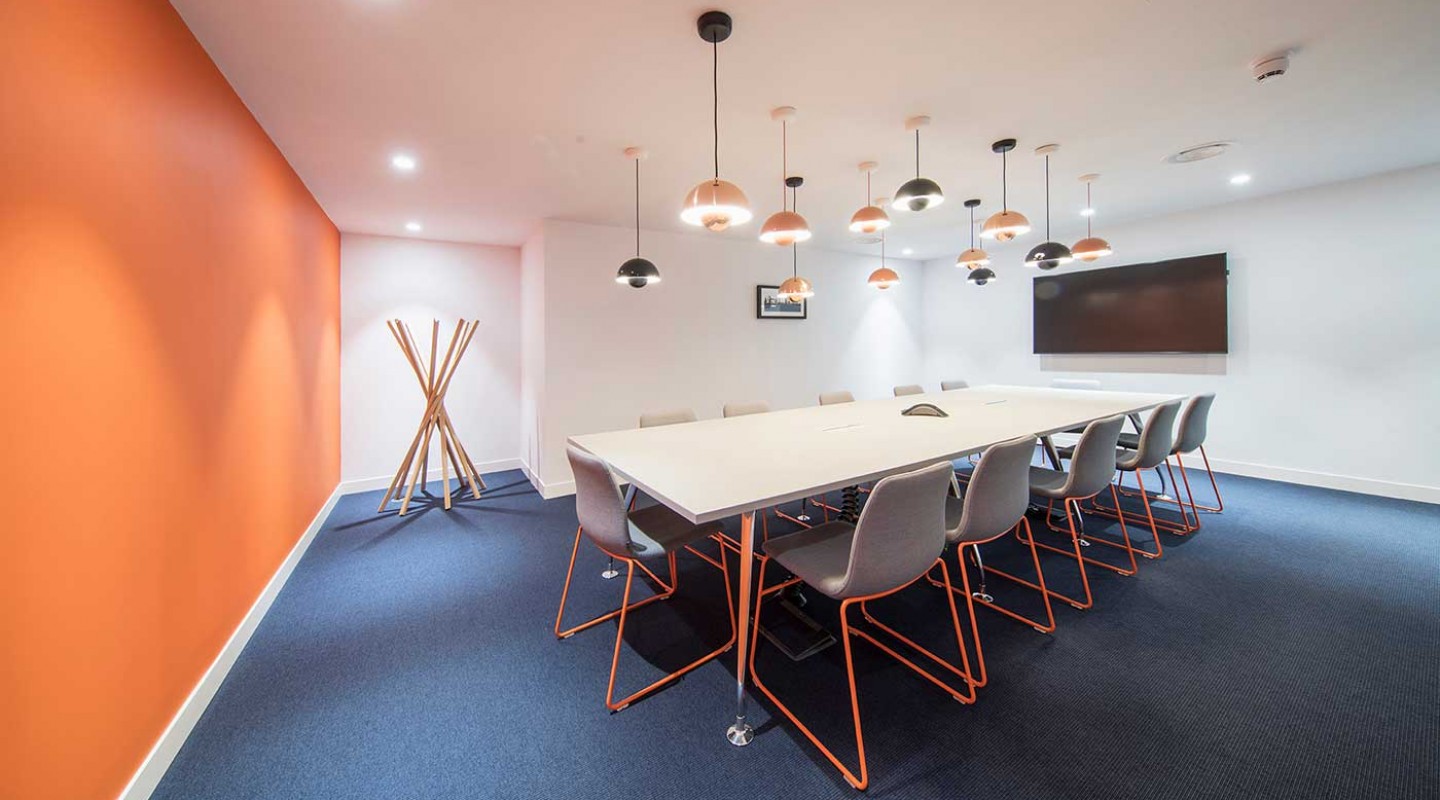 Modern meeting room with sleek table, ideal for presentations and brainstorming.