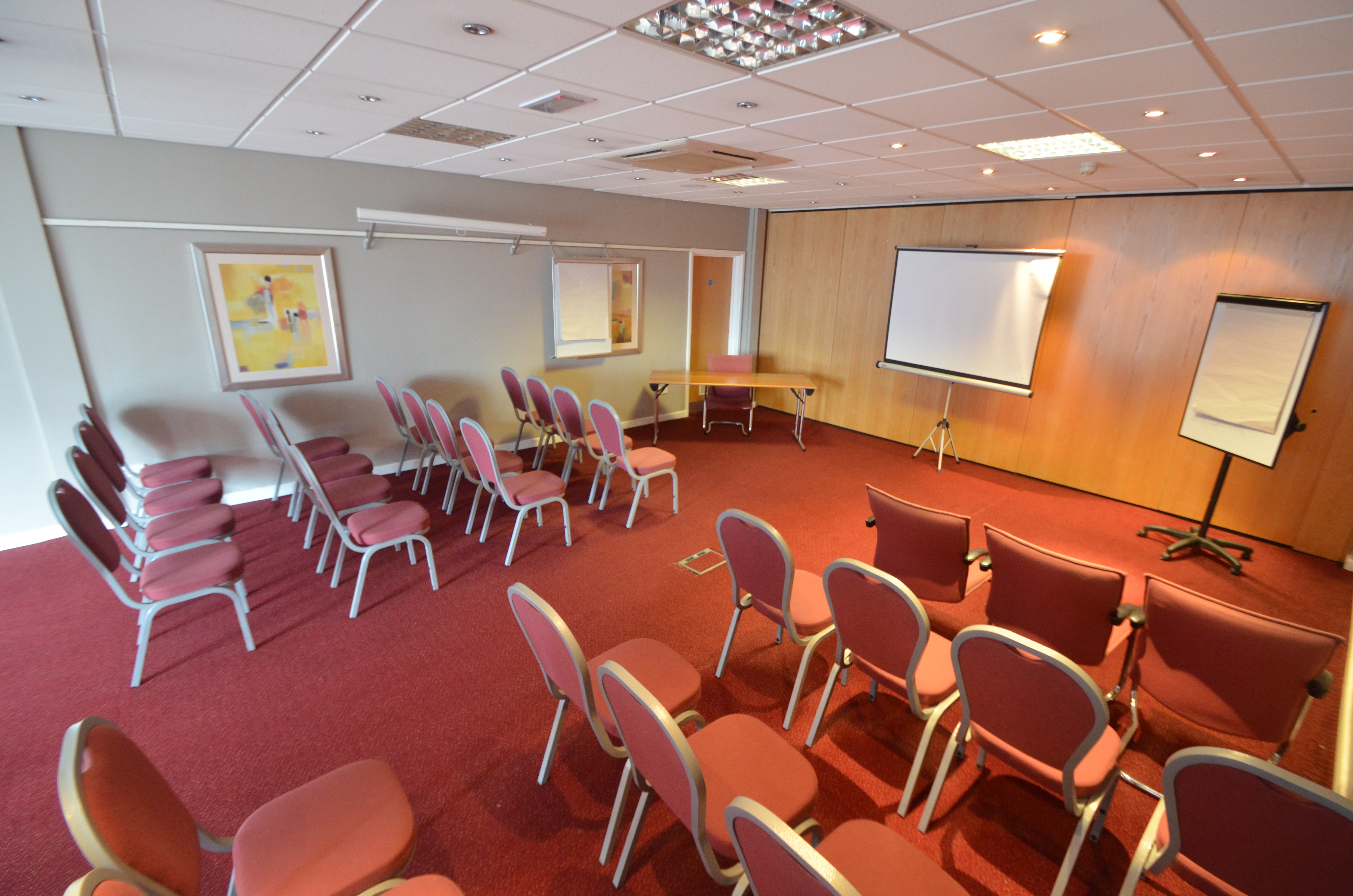 Victoria Suite meeting room with chairs, projector screen for workshops and conferences.