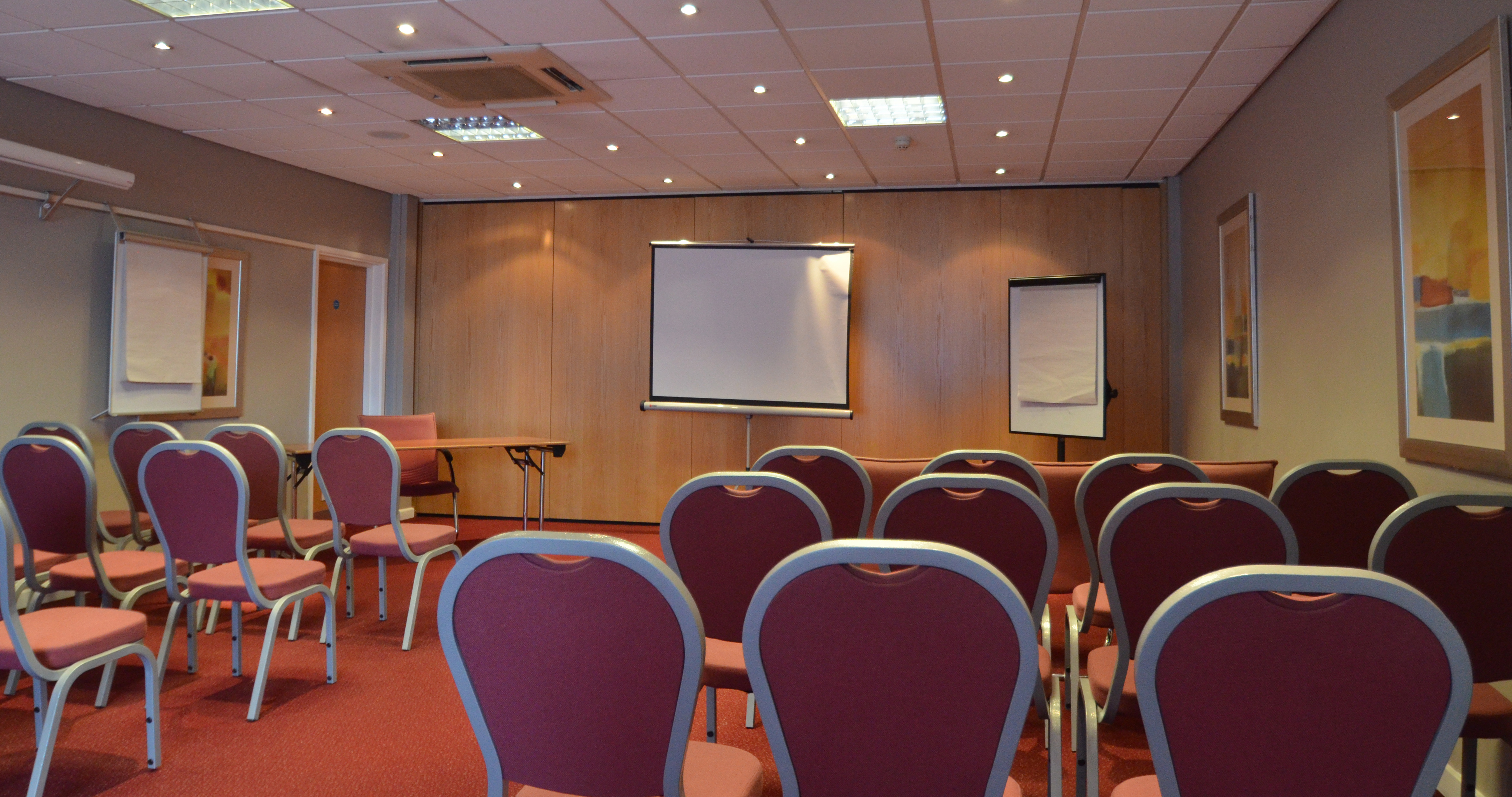 Victoria Suite meeting room with chairs and presentation screen at Holiday Inn Express Park Royal.