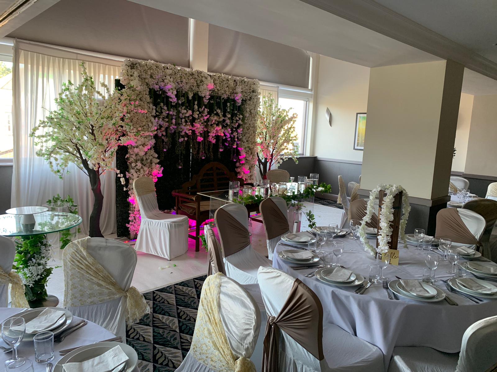 Elegant event space with floral backdrop, perfect for weddings and upscale gatherings.