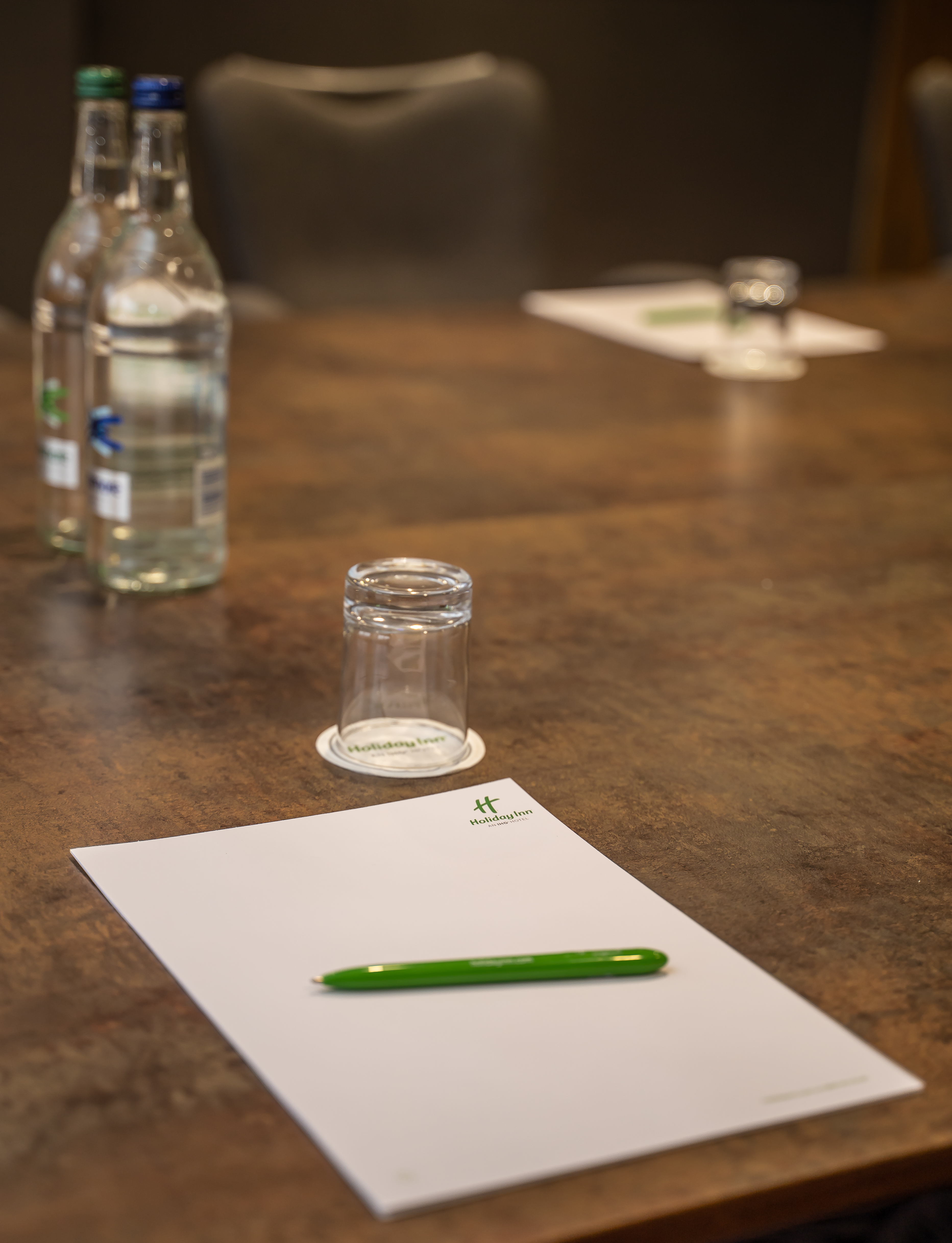 Leicester Suite meeting setup with polished table, notepads, and water bottles.