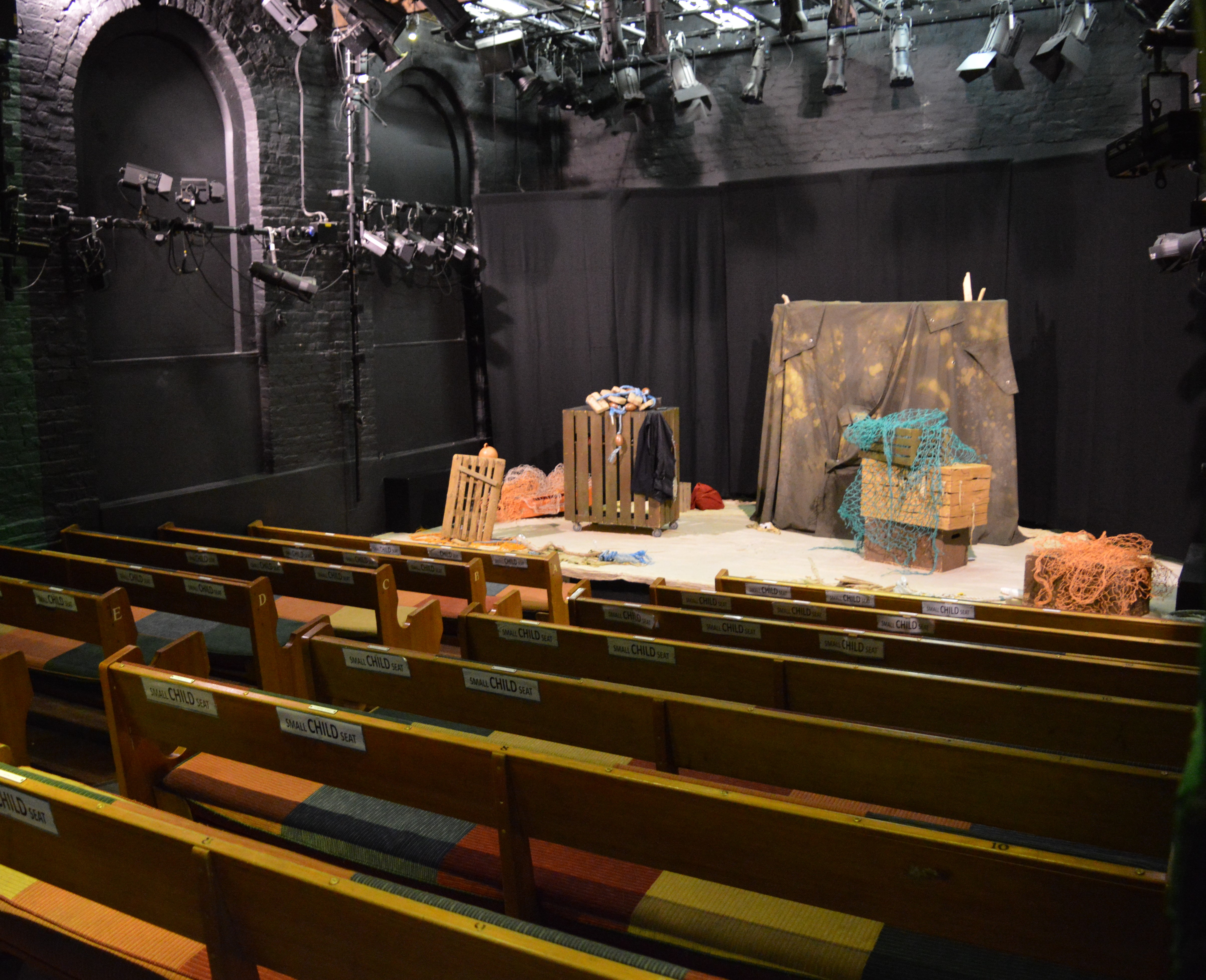 Intimate wooden bench theater setup at Little Angel Theatre for workshops and performances.