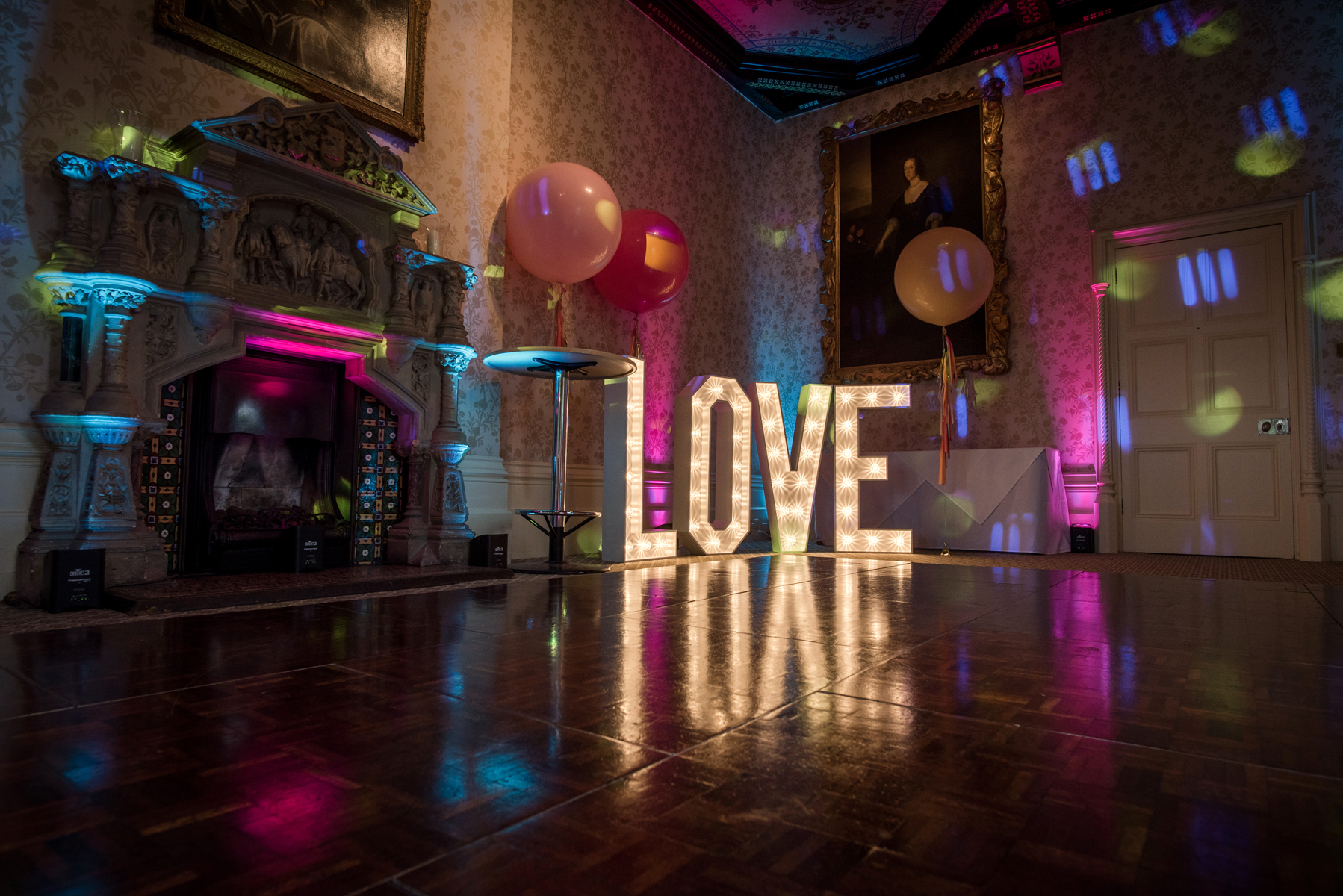 Elegant wedding venue with illuminated "LOVE" letters and vibrant lighting in Hampshire.