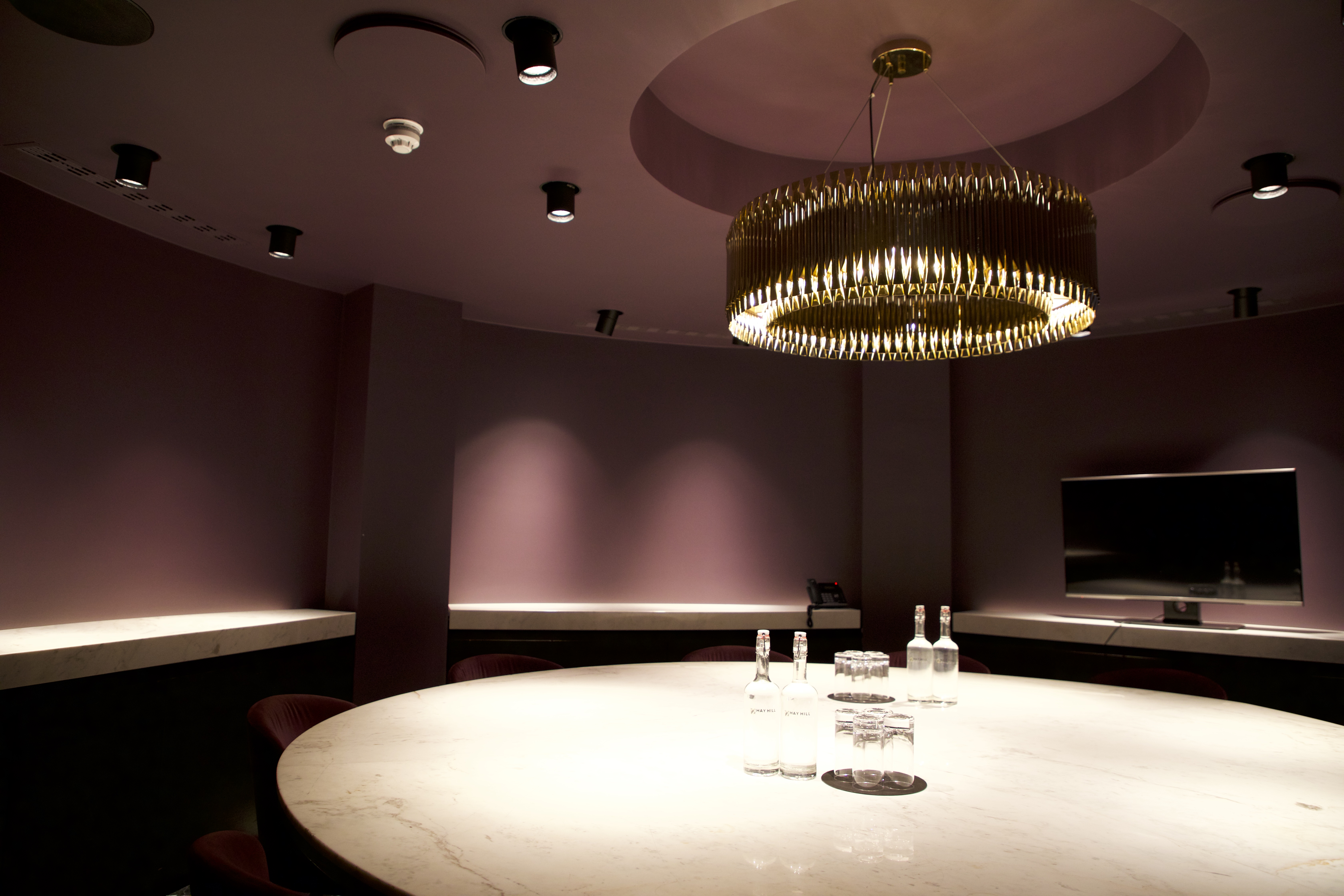 Modern meeting space with round table and elegant lighting for focused discussions.