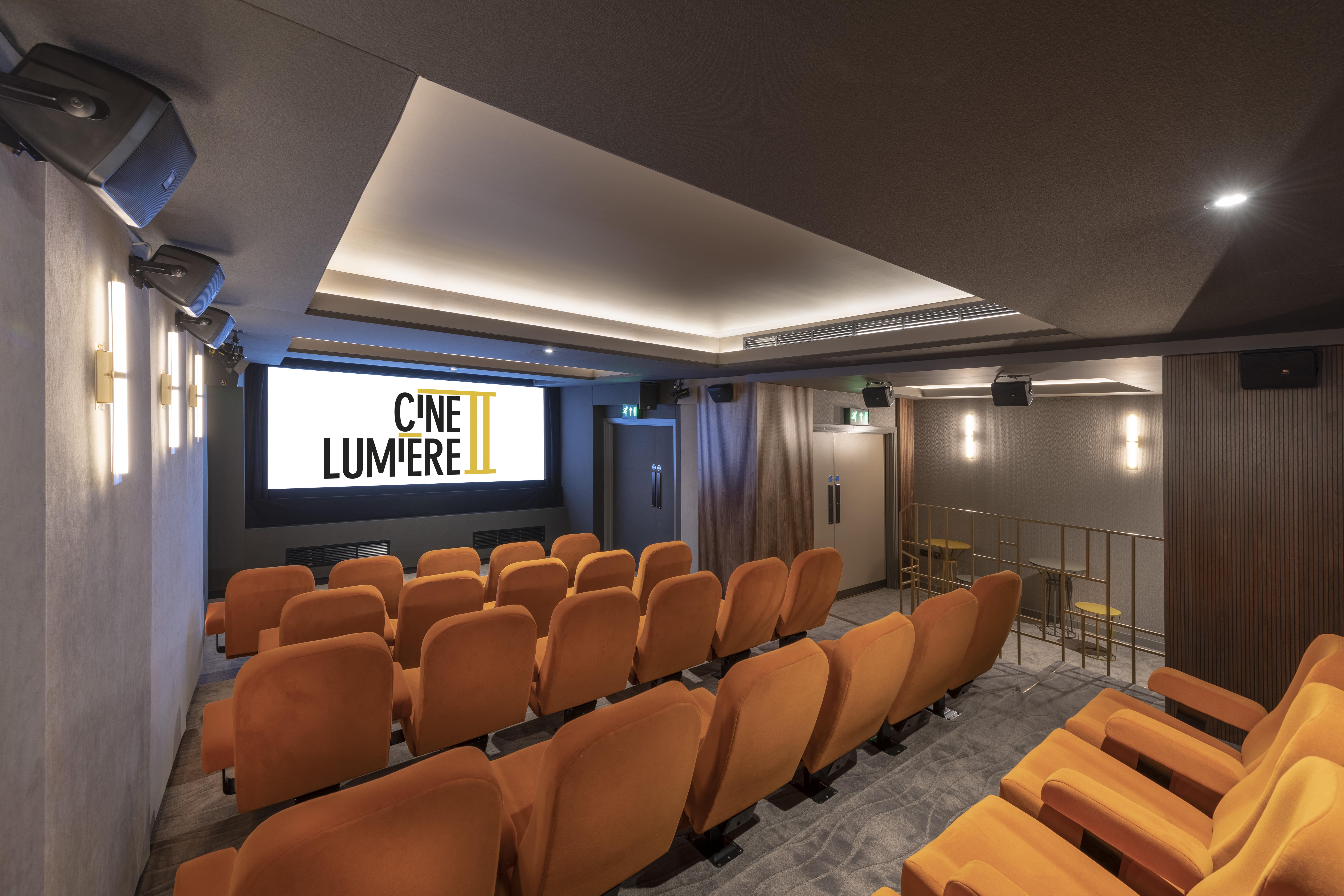Ciné Lumière 2 theater with orange seating, ideal for corporate events and film screenings.