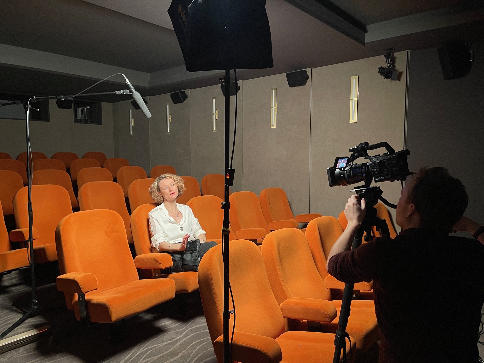 Ciné Lumière 2 theater with orange seating for engaging presentations and interviews.