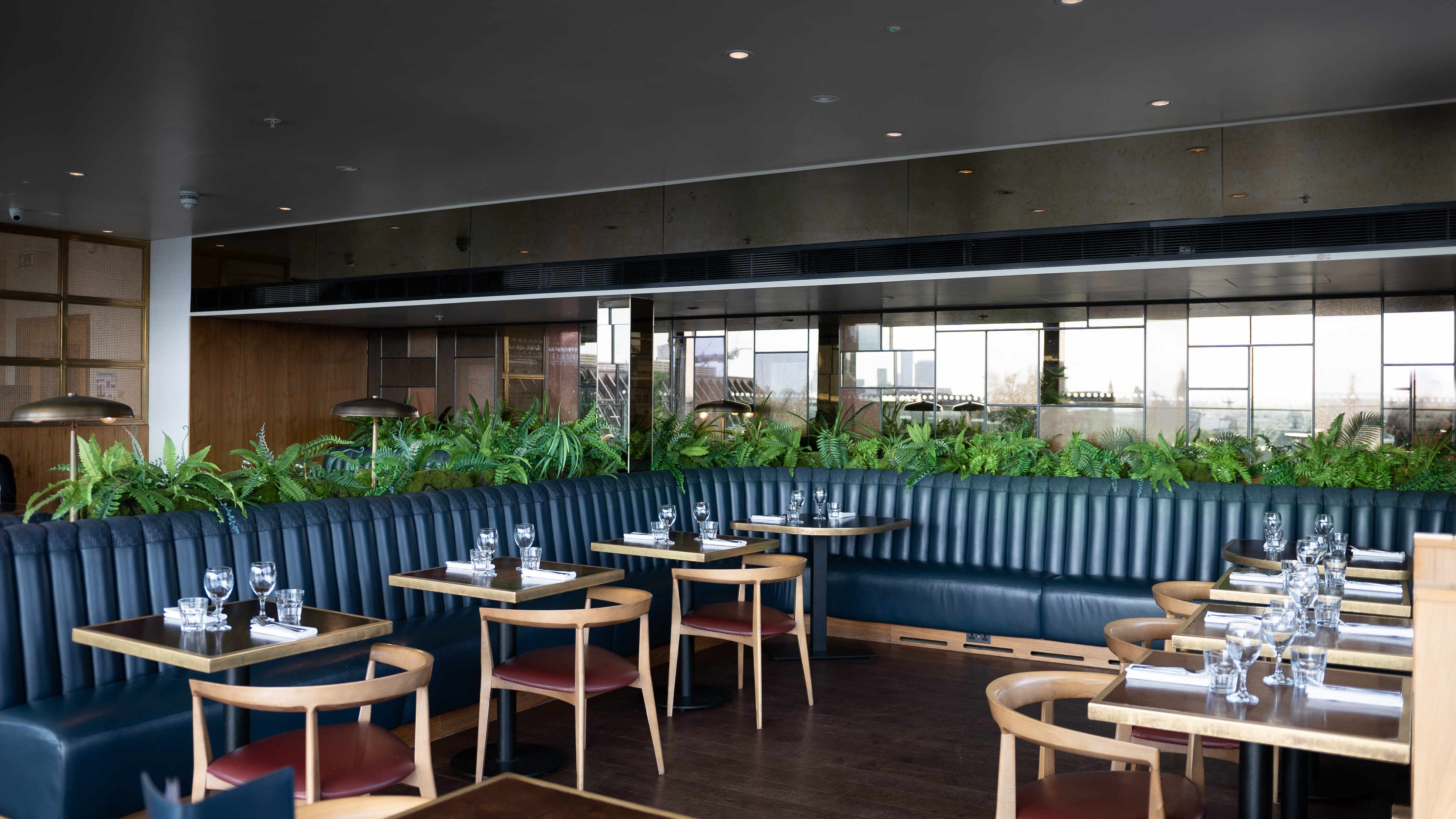 Modern LSQRooftop venue with dark furnishings, perfect for intimate events and networking.