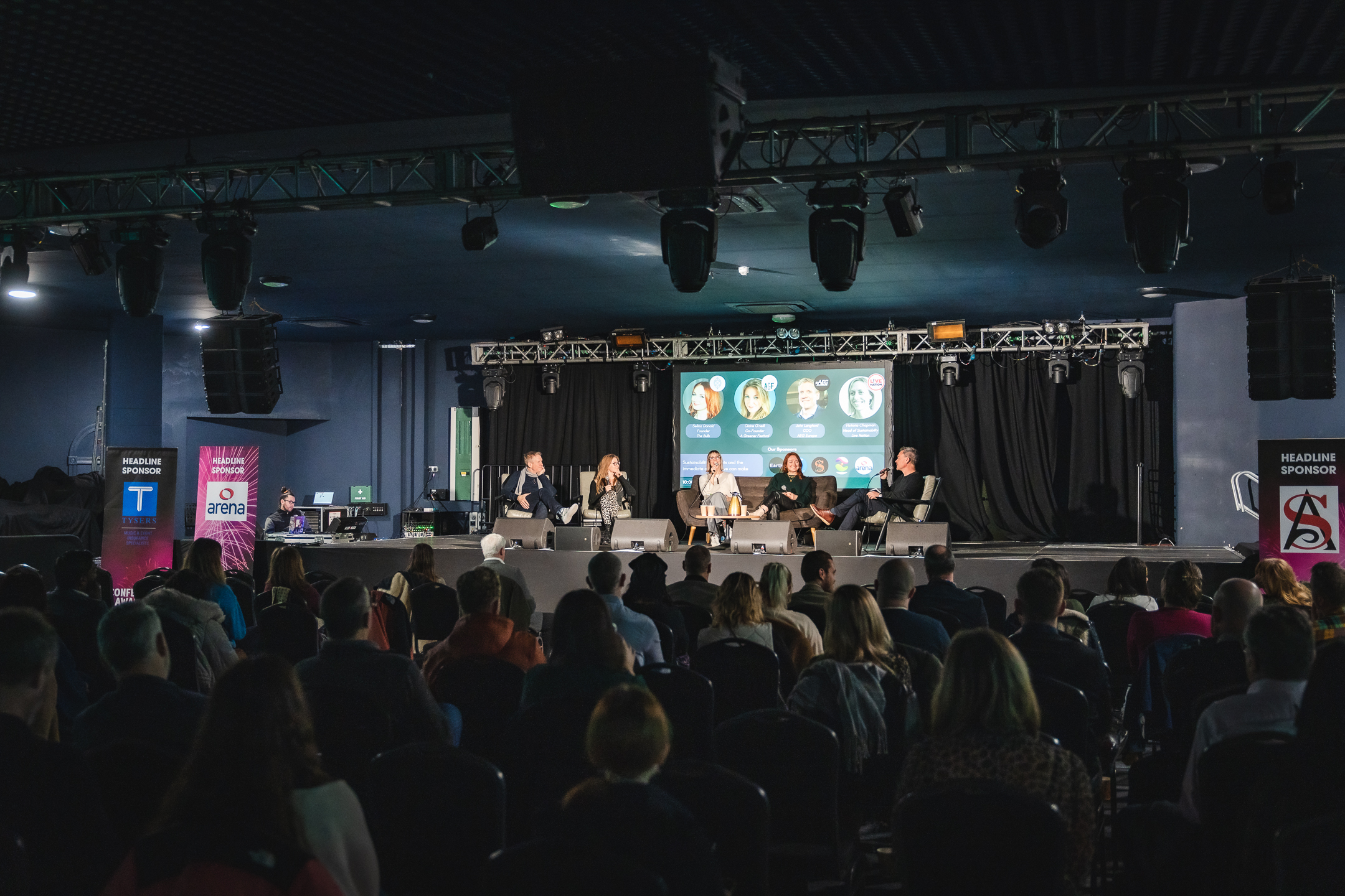 Panel discussion at EartH Concert Hall with engaged audience and professional setup.