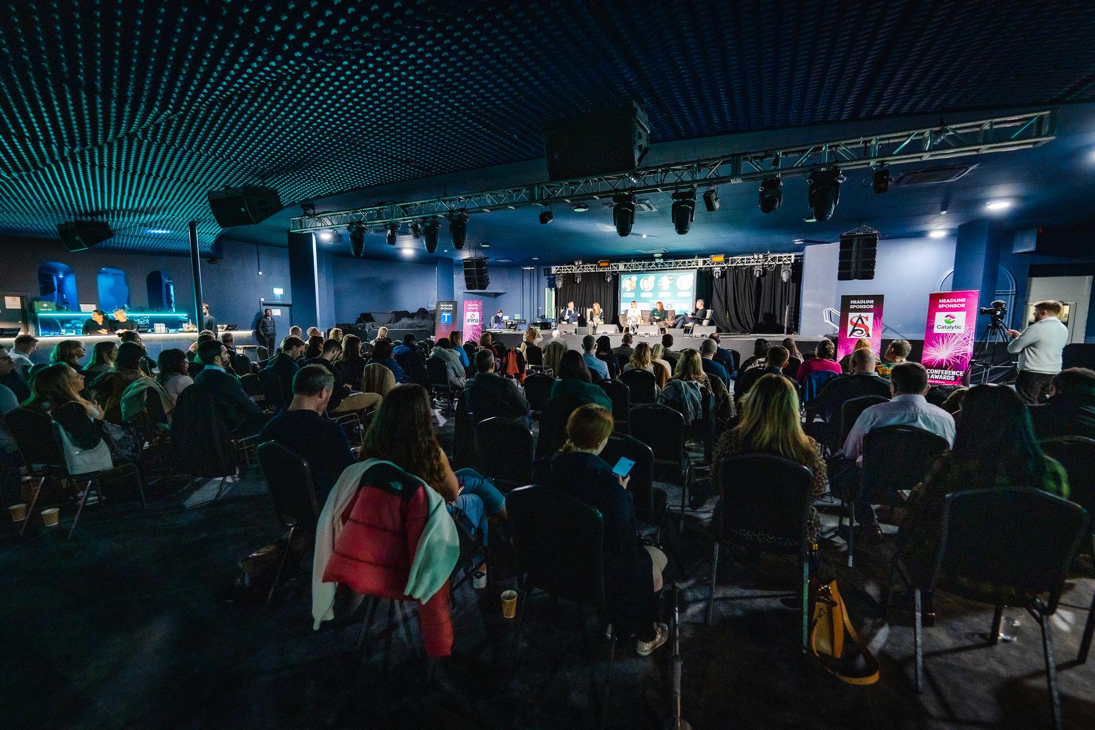 Engaged audience at EartH concert hall during a professional conference event.