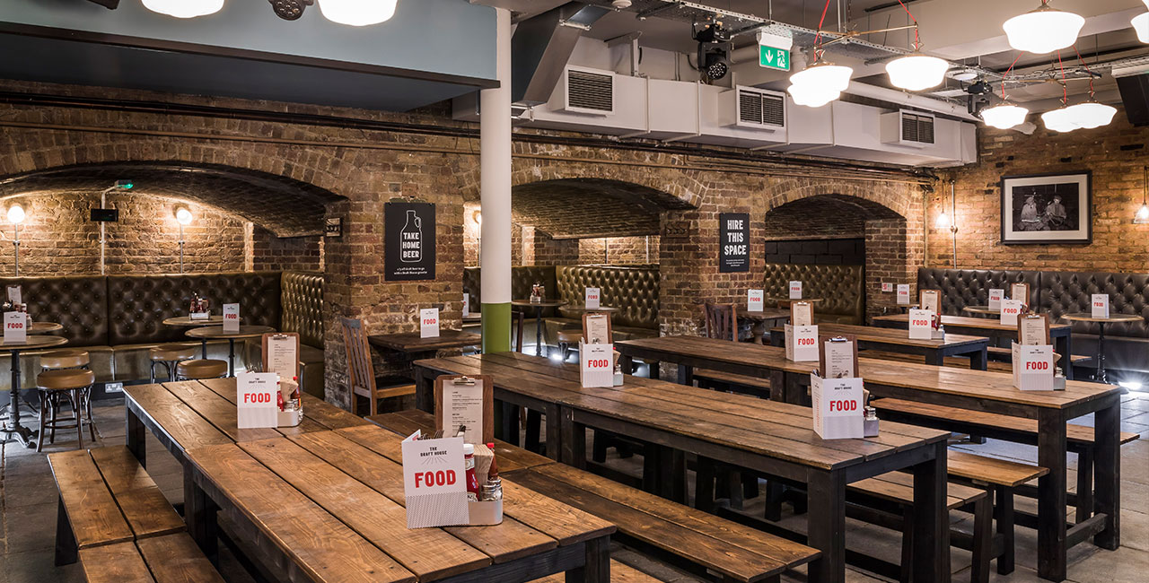 Spacious Beer Hall with rustic tables, ideal for casual gatherings and networking events.