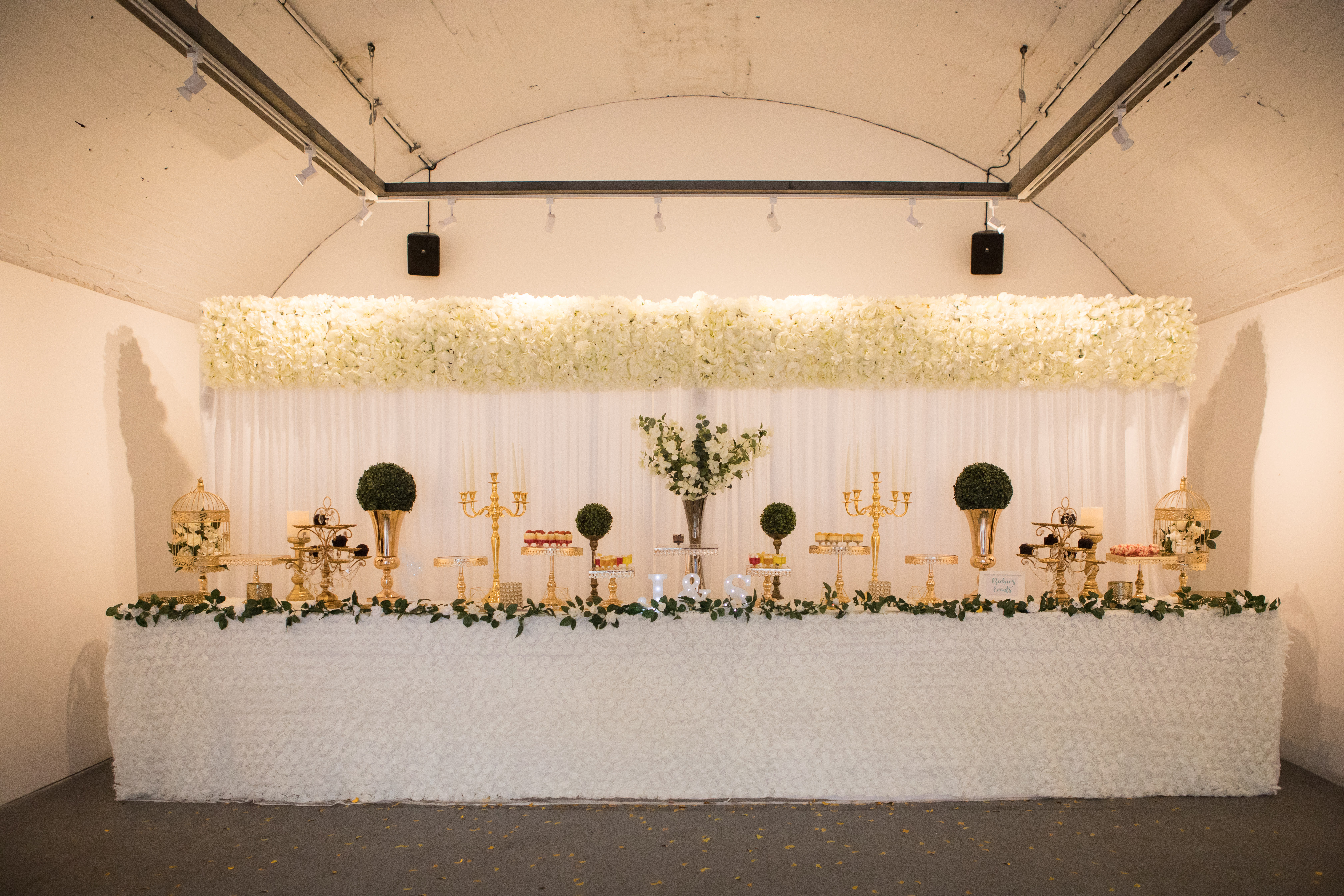 Elegant event display at The Sassoon Gallery with floral backdrop for weddings.