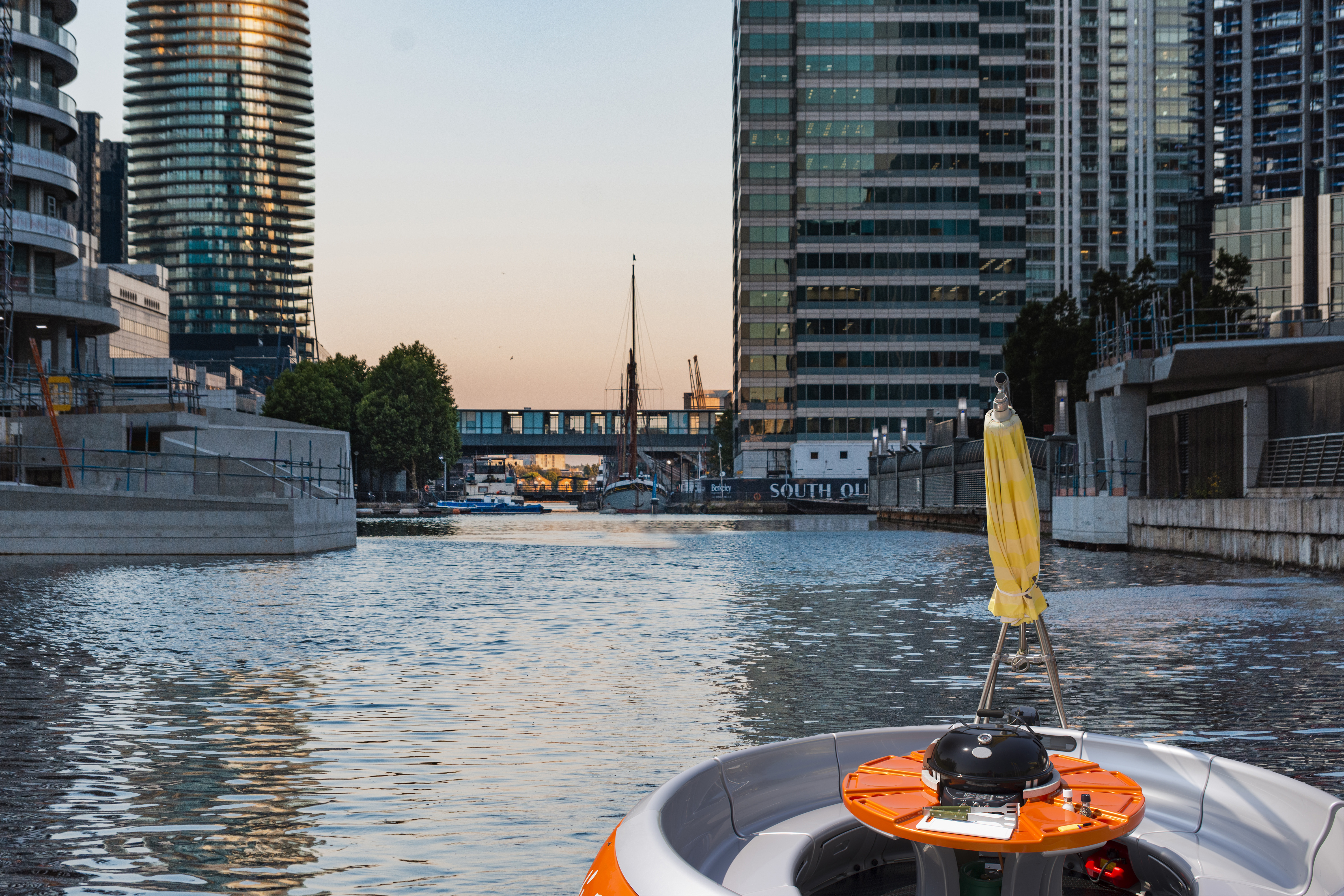 BBQ Boat on serene waterway, ideal for outdoor events and team-building activities.
