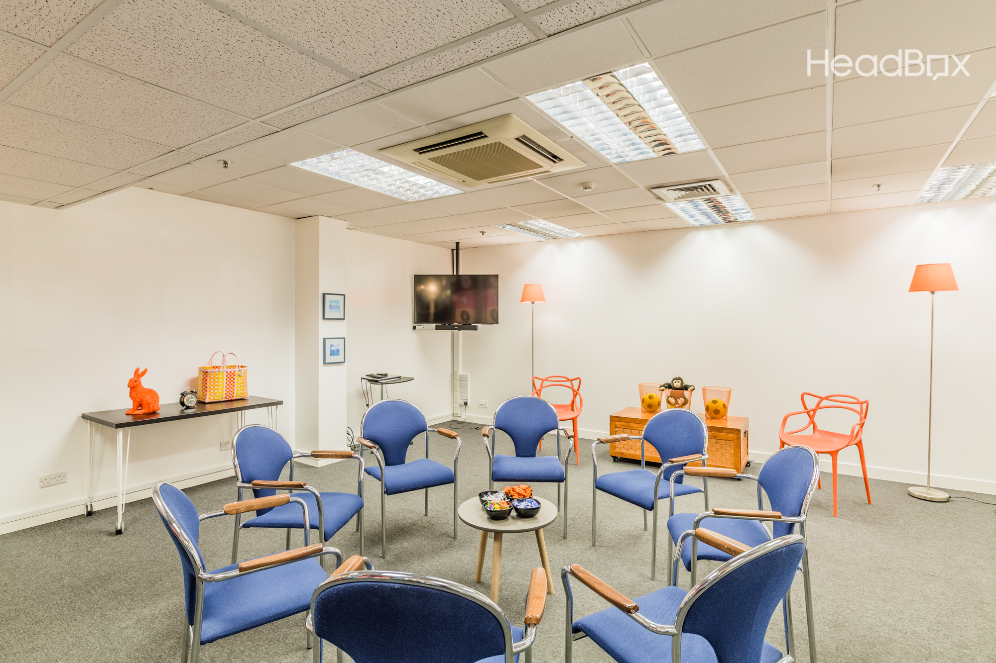 Cosy Room at Impact Factory: circular seating for workshops and meetings, warm lighting.