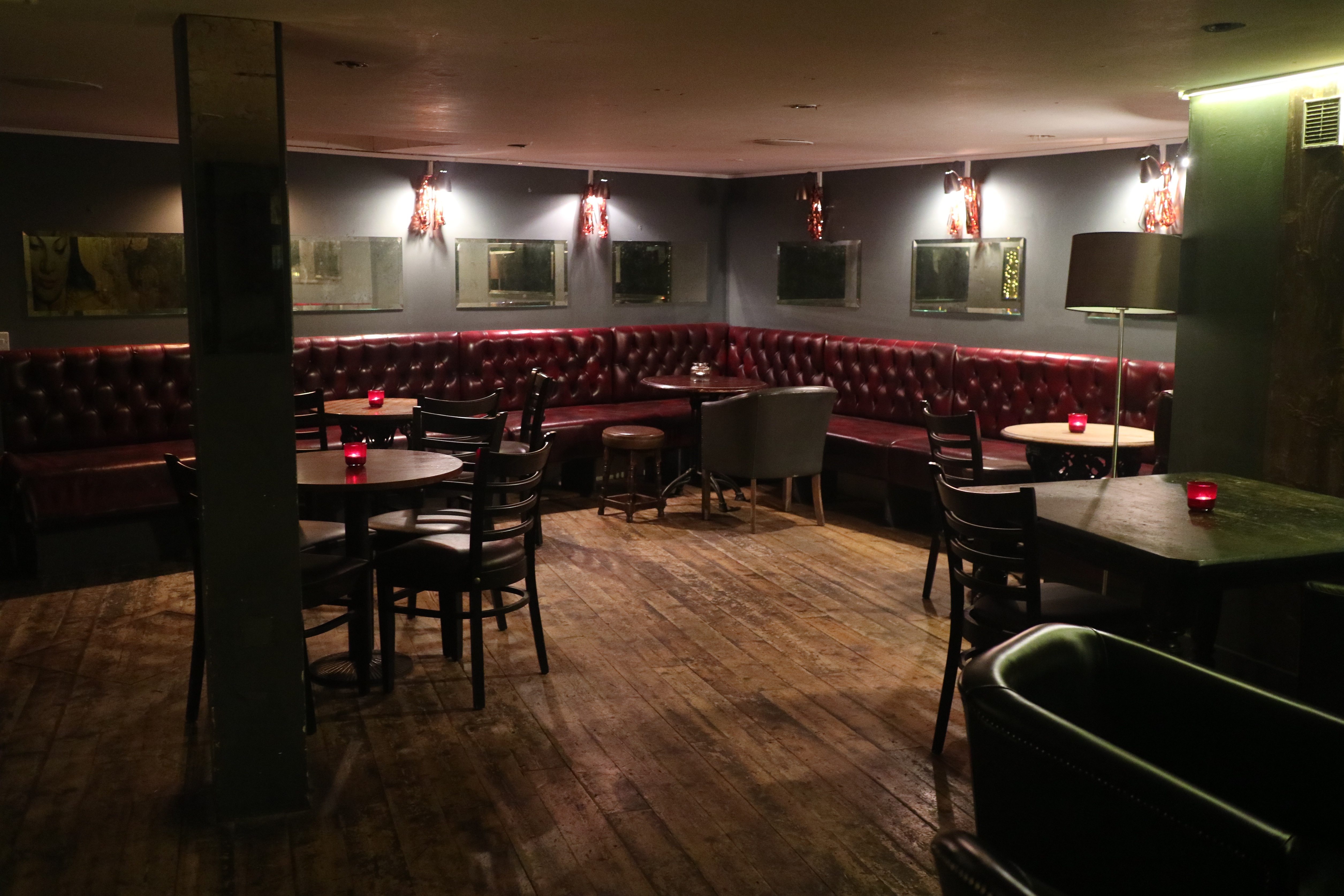 Cozy basement event space at The Regent Pub with leather seating for gatherings.