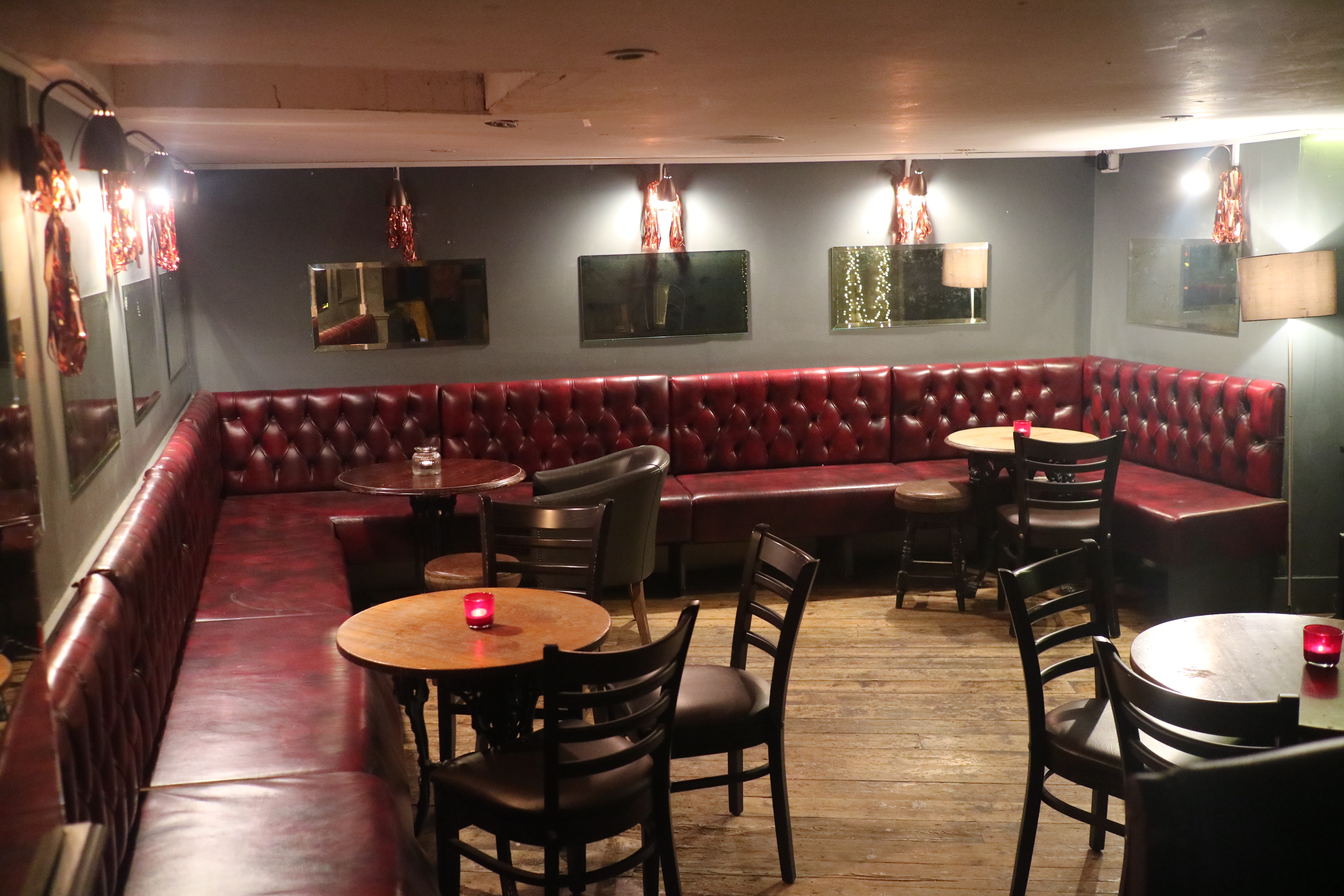 Cozy basement venue with plush seating, ideal for meetings and events at The Regent Pub.