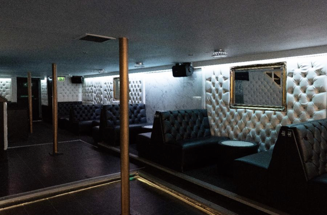 Modern event space with plush seating and polished dance floor for gatherings.