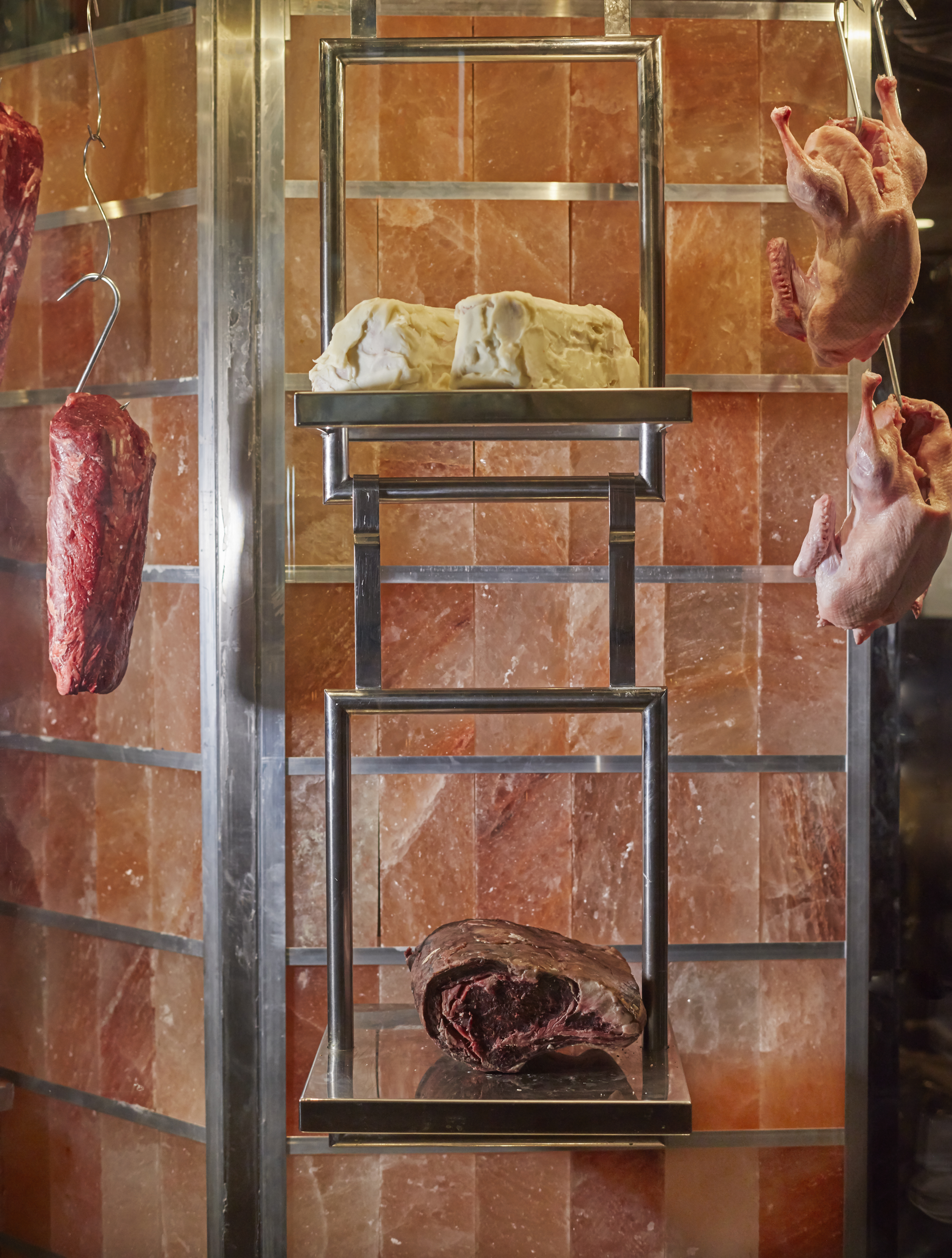 Upscale GRILL display with hanging meats and salt blocks for gourmet events.