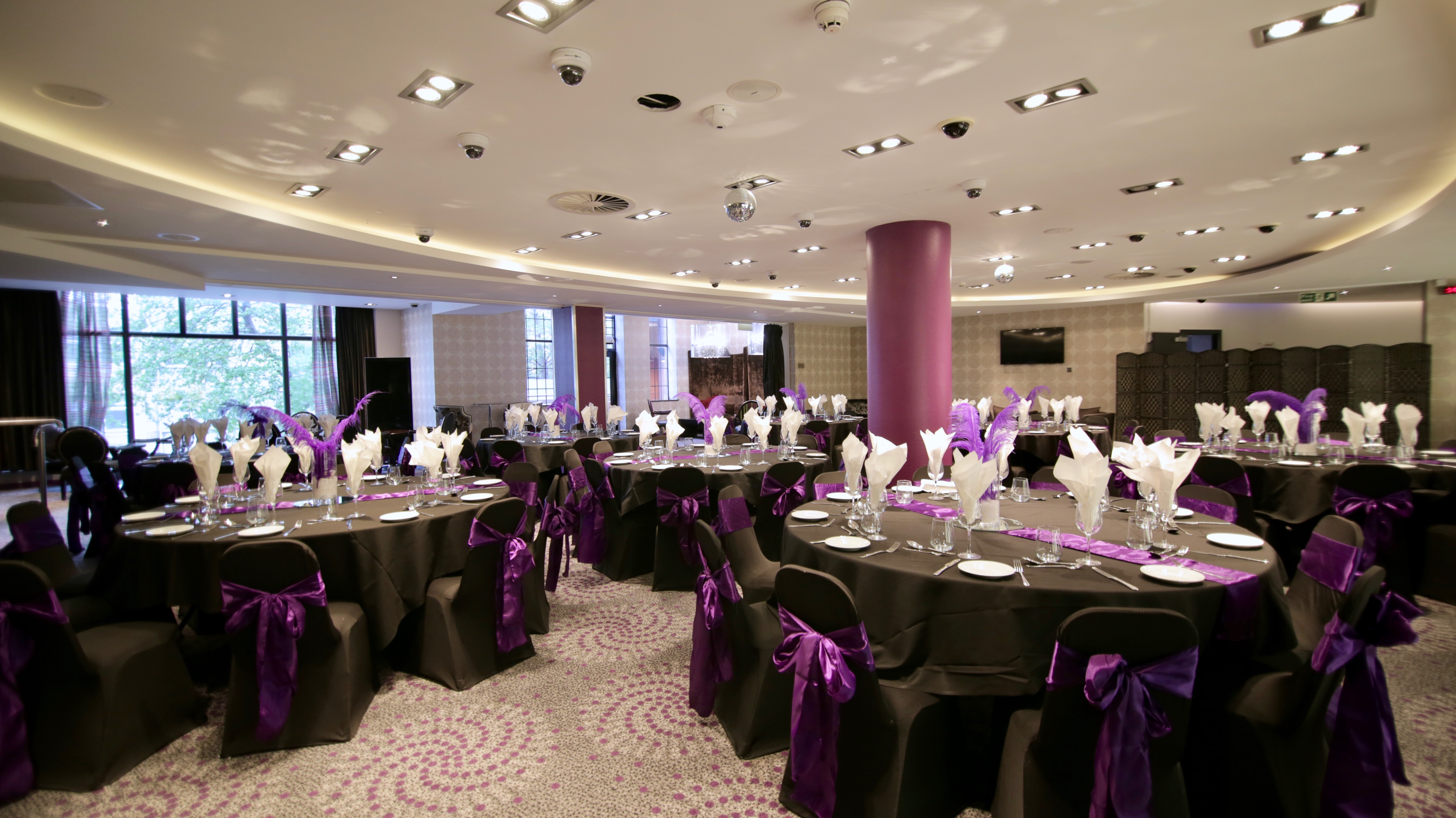 Elegant dinner setup at Alea Casino's Party Pit with black linens and purple accents.