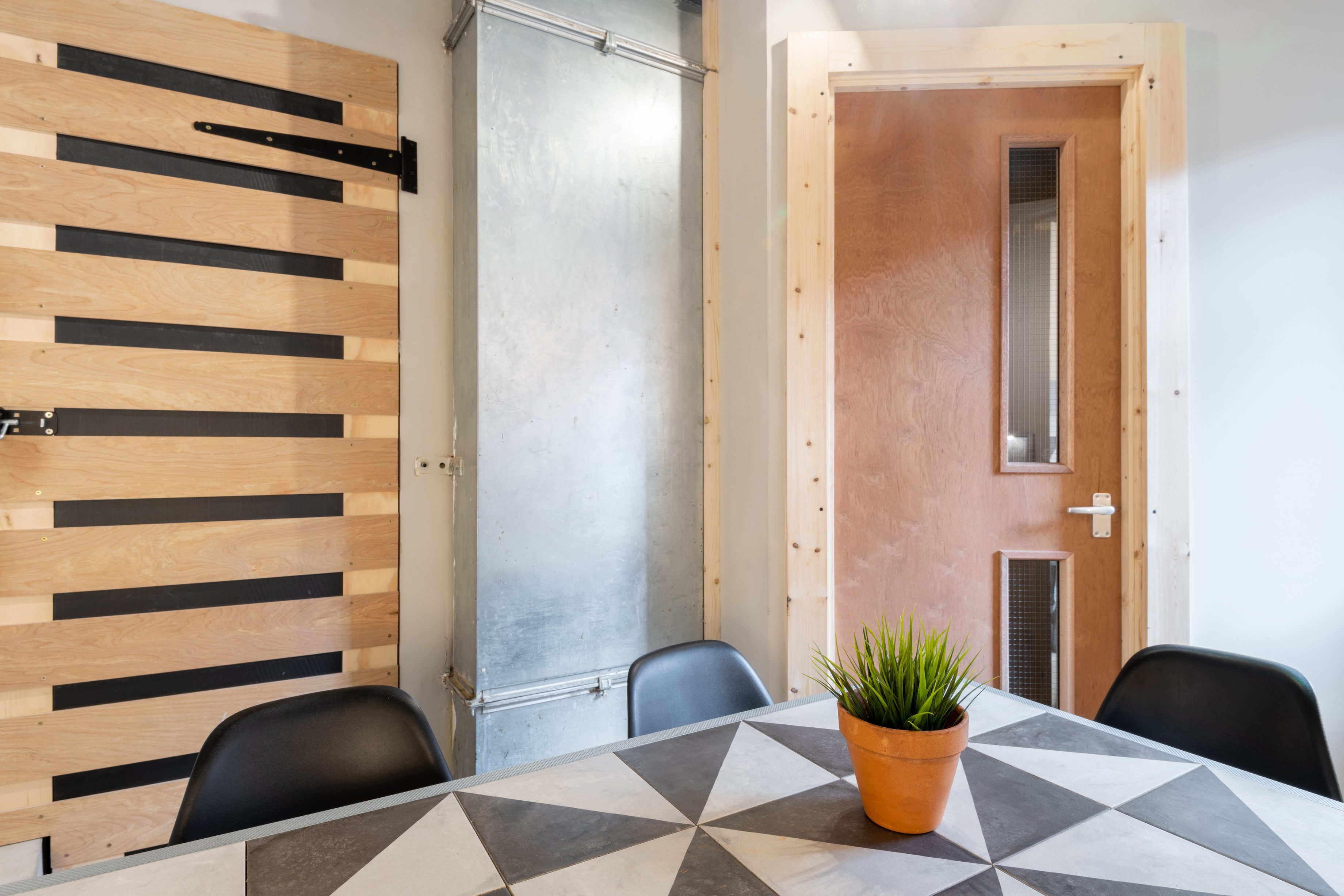 Modern meeting room with geometric table, ideal for creative brainstorming sessions.