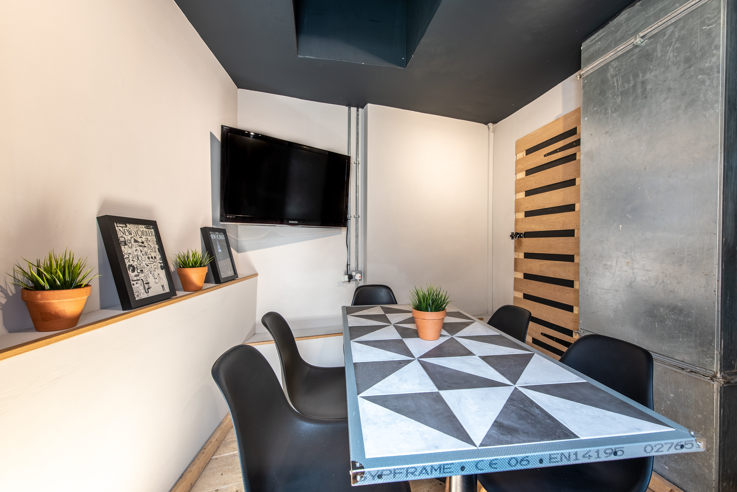 Modern meeting room with geometric table, ideal for workshops and brainstorming sessions.