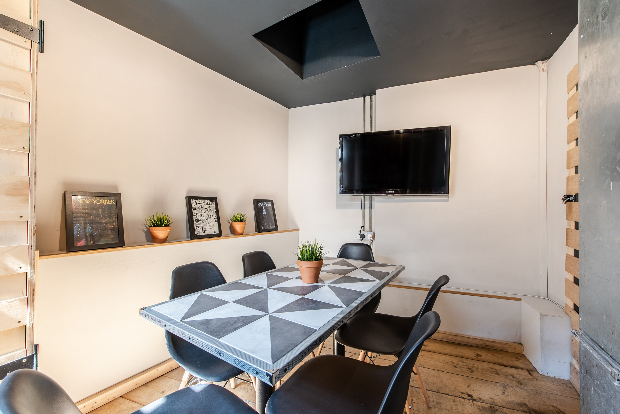 Modern meeting room with geometric table, ideal for brainstorming sessions and presentations.