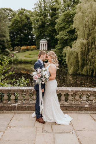 Romantic wedding venue at Hillsborough Castle with lush greenery and serene water backdrop.