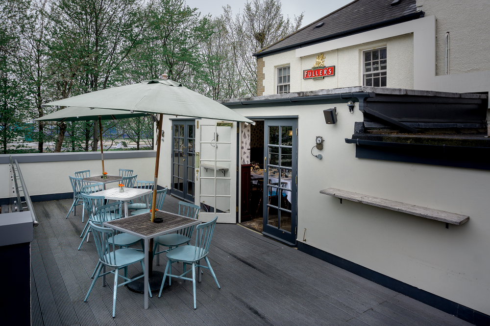 Outdoor terrace at The Bridge, featuring light blue chairs for networking events.