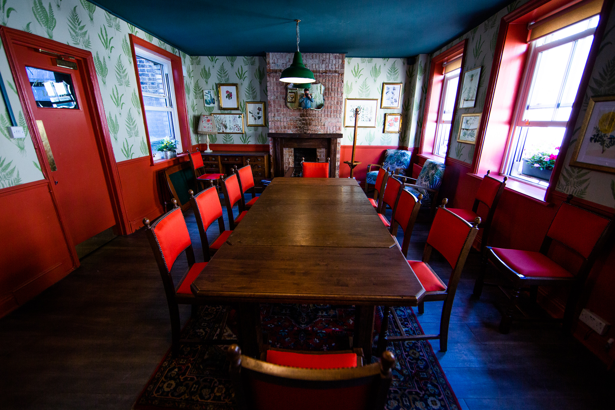 Cozy meeting room with wooden table and red chairs at Bow Street Tavern for gatherings.