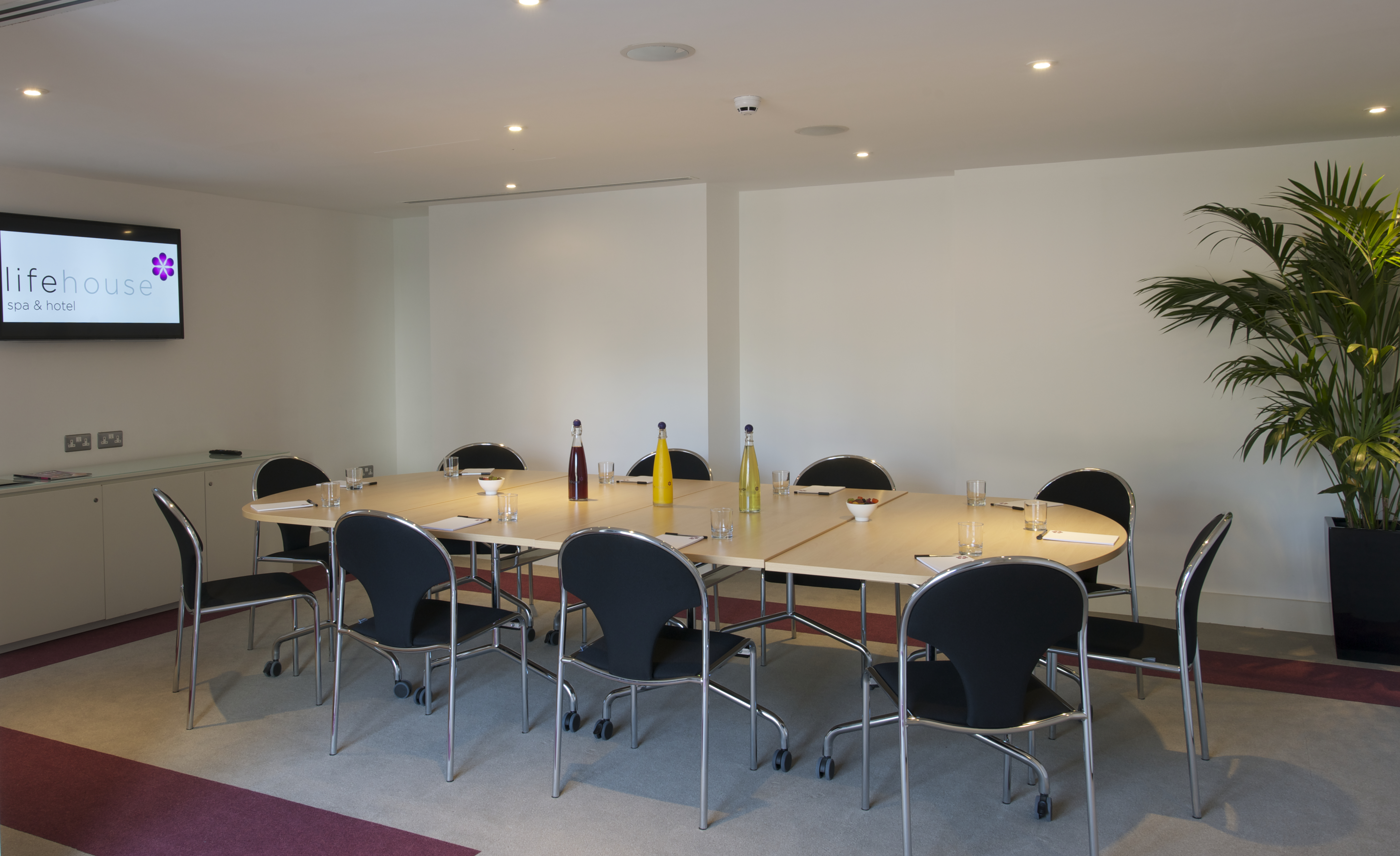 Modern meeting room in Thorpe Suite, Lifehouse Spa; oval table, tech-ready for events.