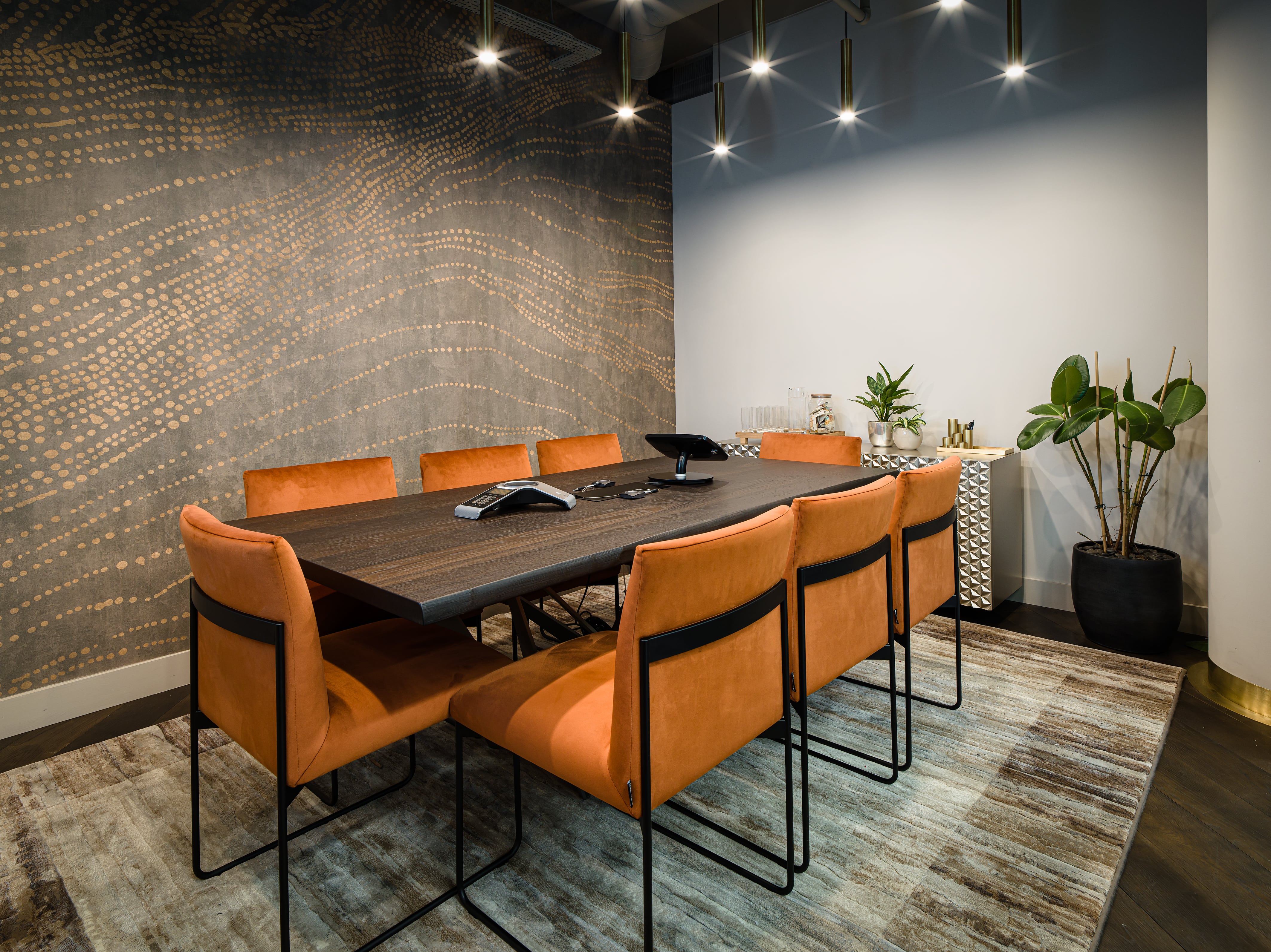 Modern conference room with wooden table and orange chairs for meetings in Uncommon Liverpool.