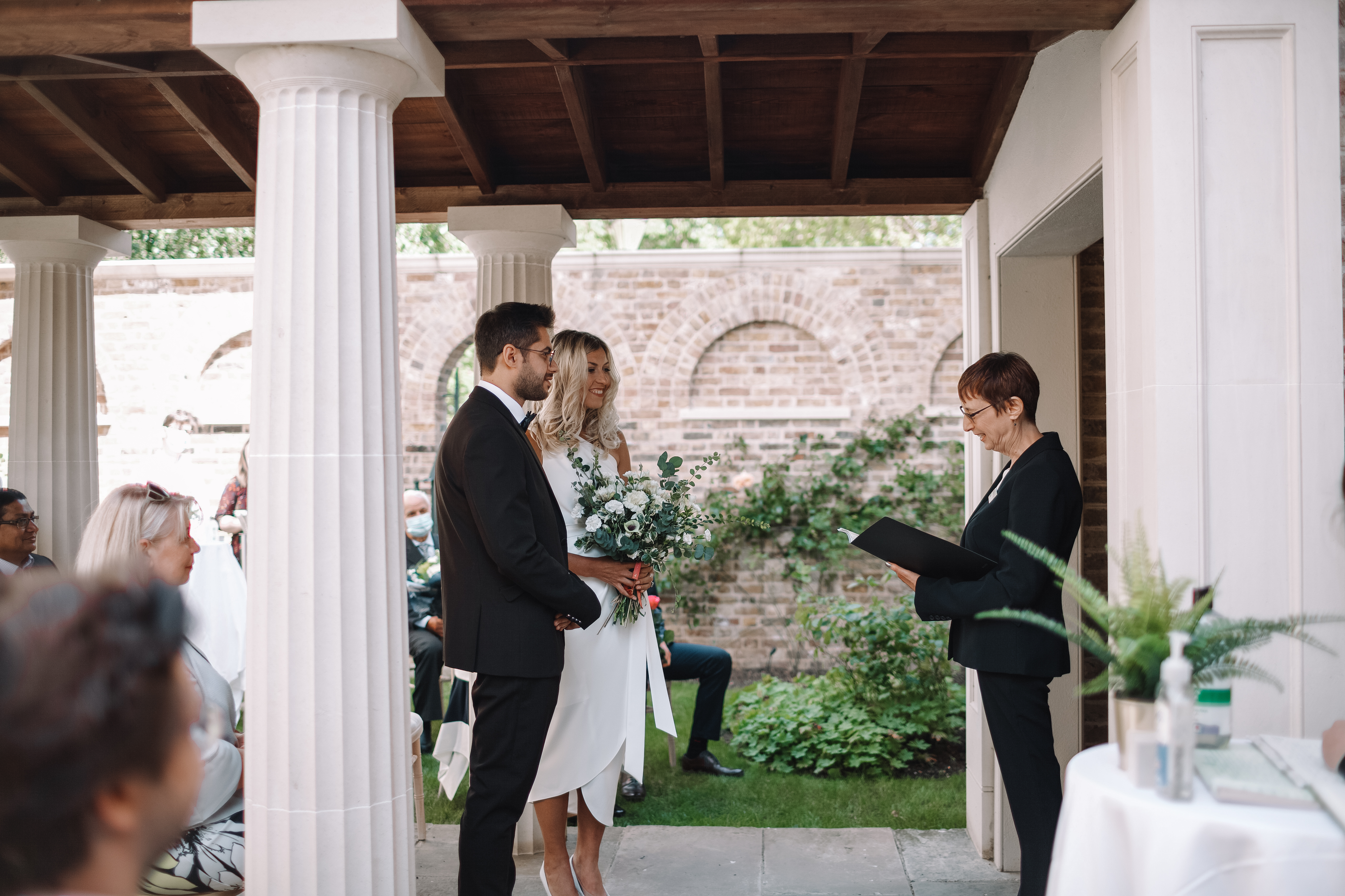 Outdoor wedding ceremony at The Colonnade, Pitzhanger Manor, featuring elegant columns.