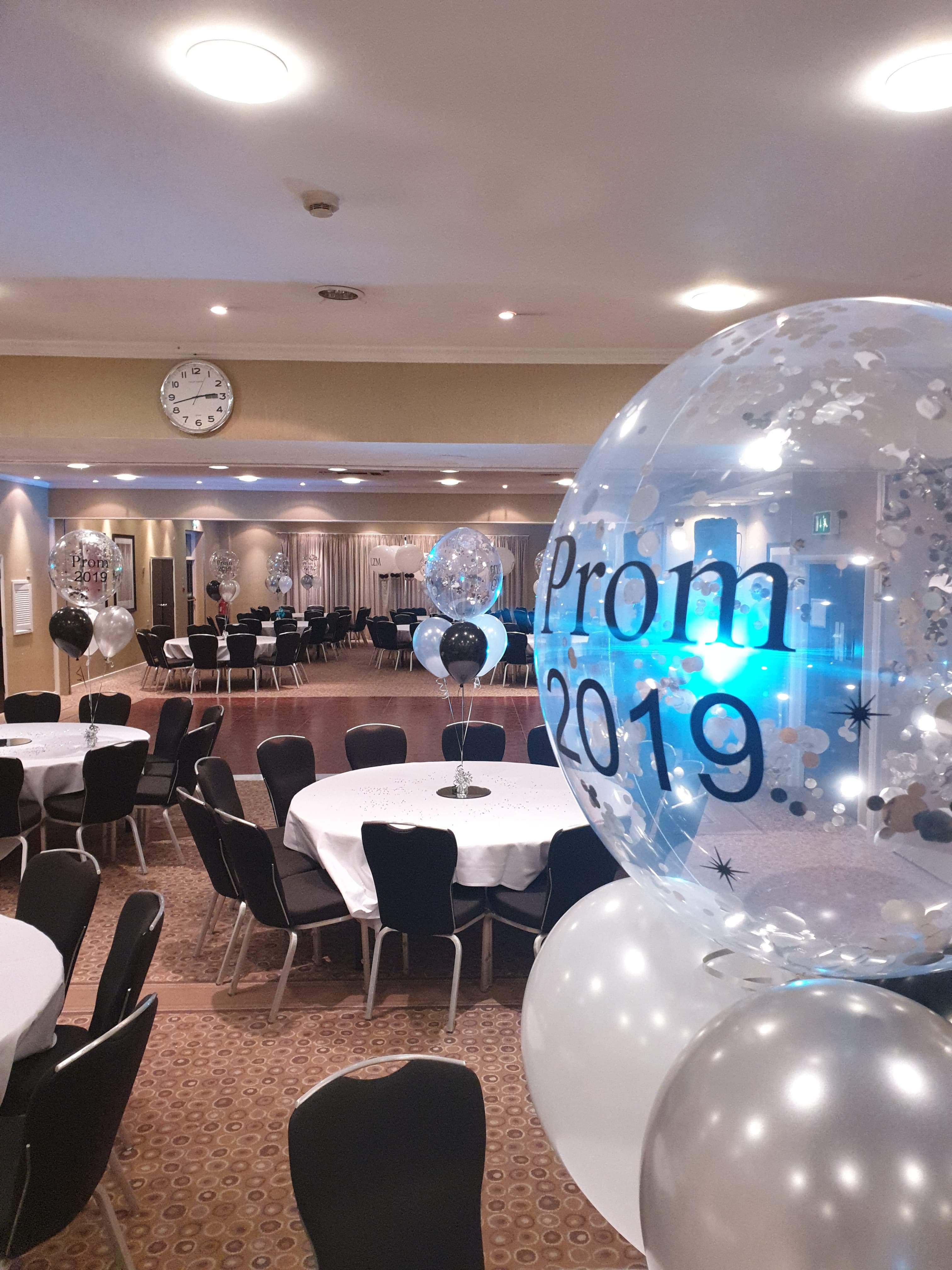 William Duesbury at a prom event in a decorated Holiday Inn space with elegant tables.