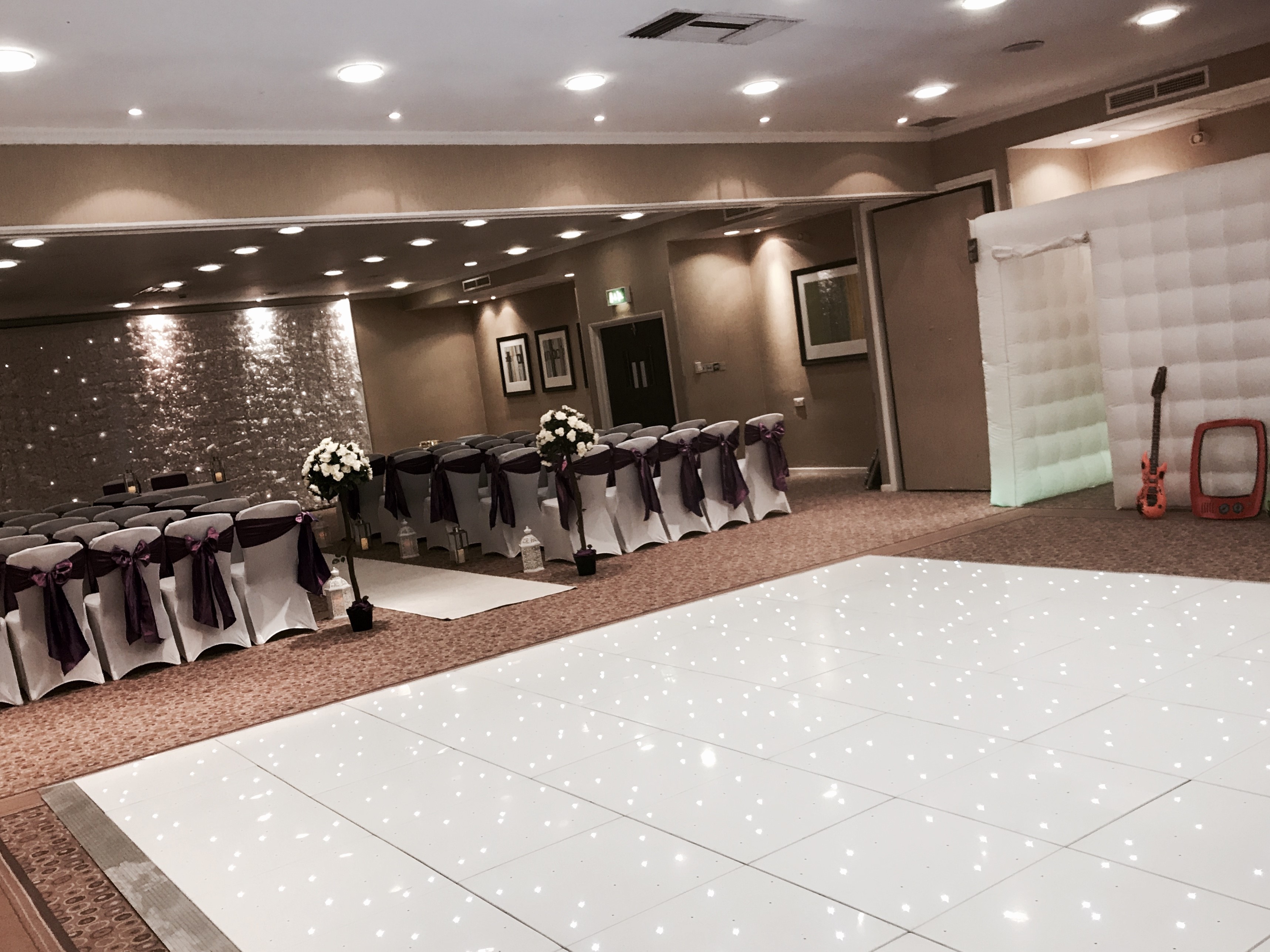 William Duesbury in elegant wedding event space with white and purple decor at Holiday Inn.